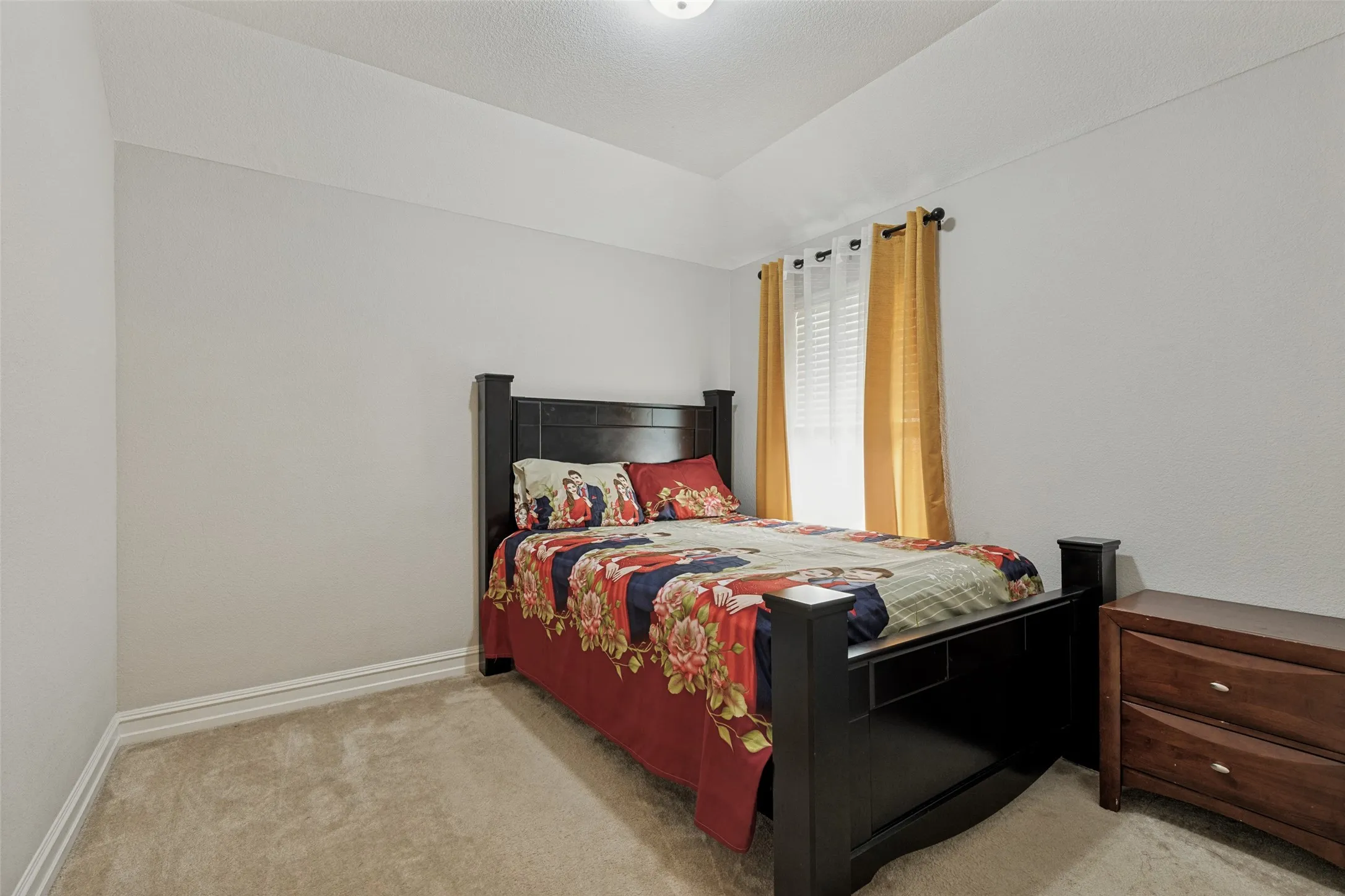 Carpeted room featuring a tray ceiling, white baseboards, and a window with blinds