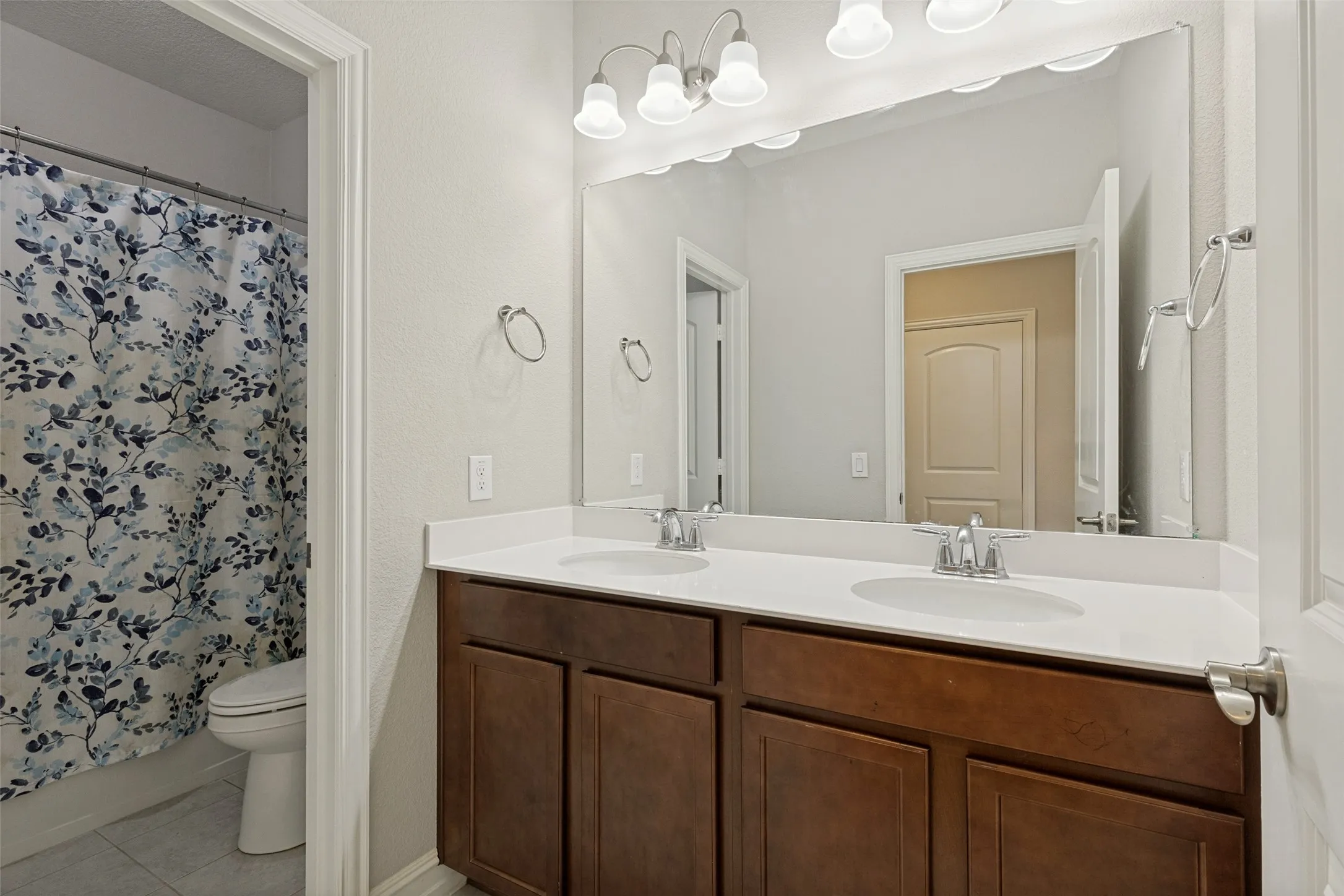 Double vanity featuring a white countertop, dual undermount sinks, and chrome faucets