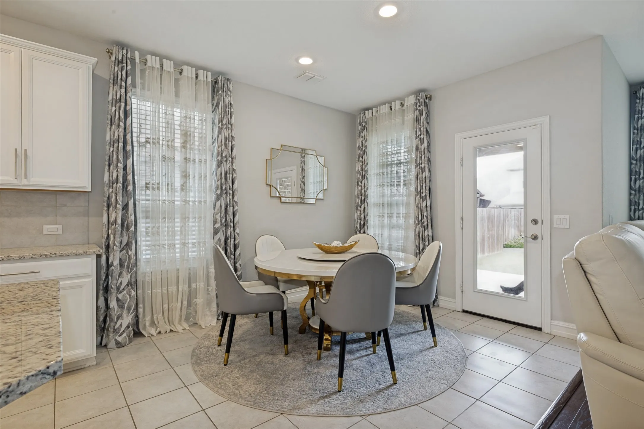 Bright dining area featuring tile flooring and a glass-paneled exterior door