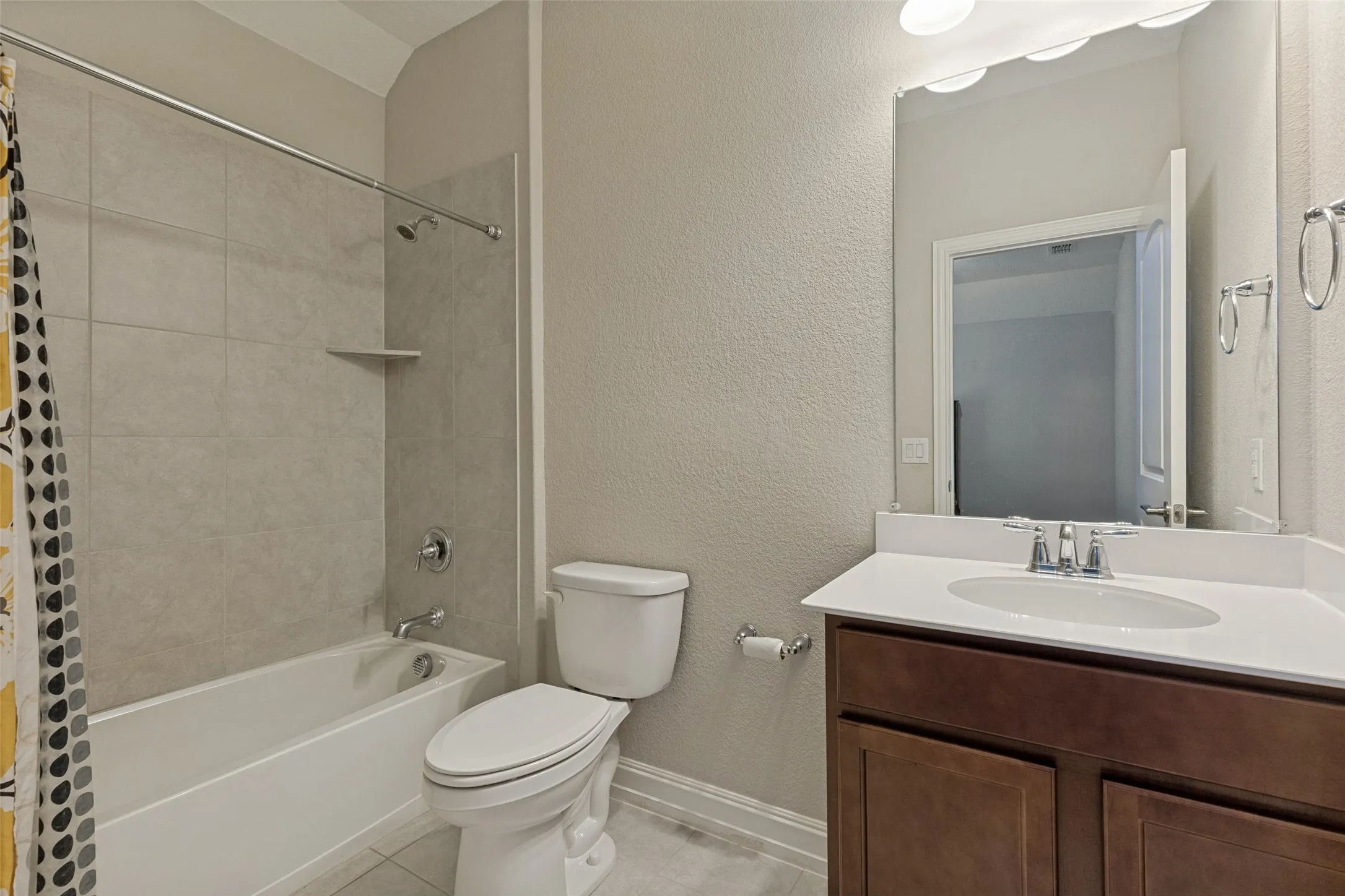 Bathroom featuring a white vanity with a rectangular sink, a large mirror, and overhead lighting