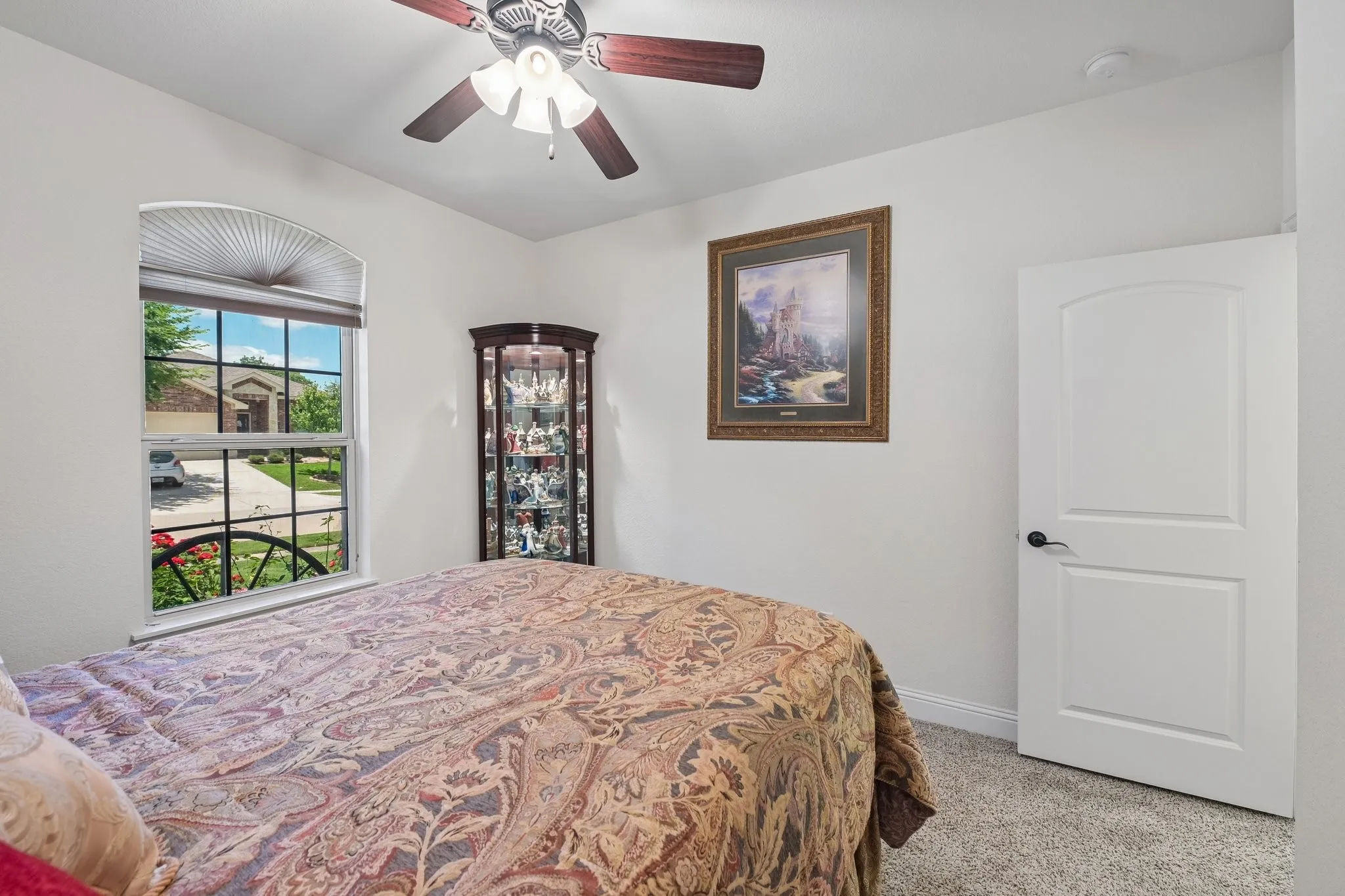 Neutral-toned walls and plush carpet flooring complement a white two-panel arched interior door