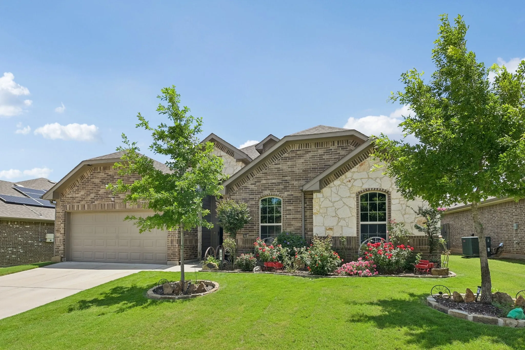 Brick and stone facade residence featuring an attached two-car garage