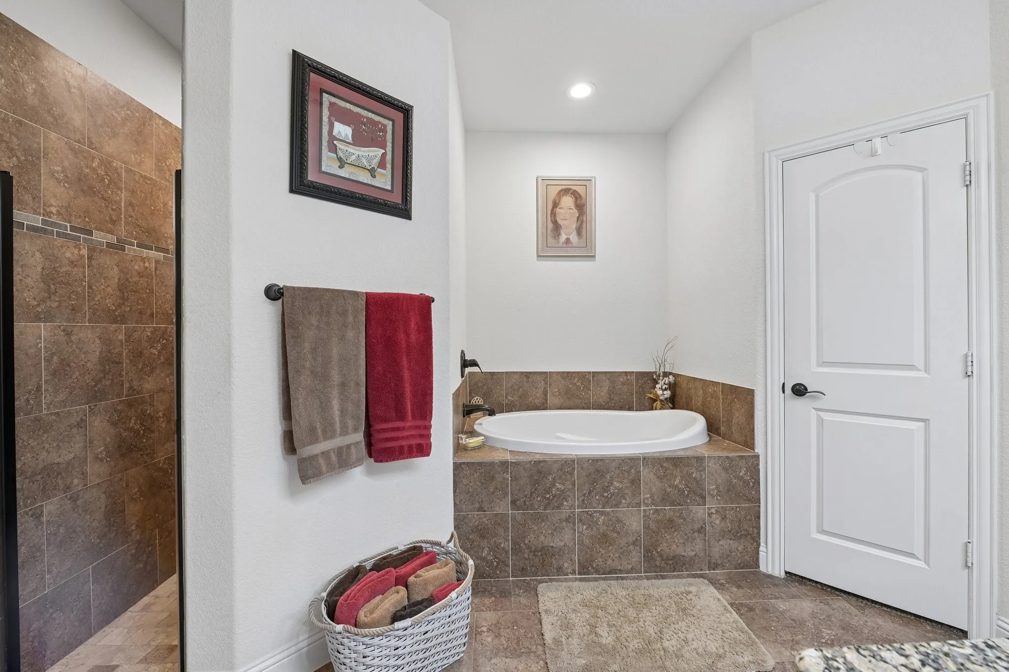 Bathroom featuring a built-in soaking tub with a tiled surround, a separate shower enclosure with tiled walls, recessed lighting, and a white paneled door