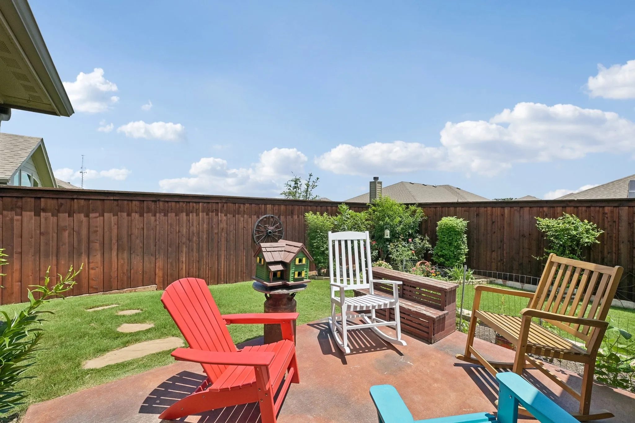 Expansive backyard featuring a concrete patio, stepping stones, and a full privacy fence