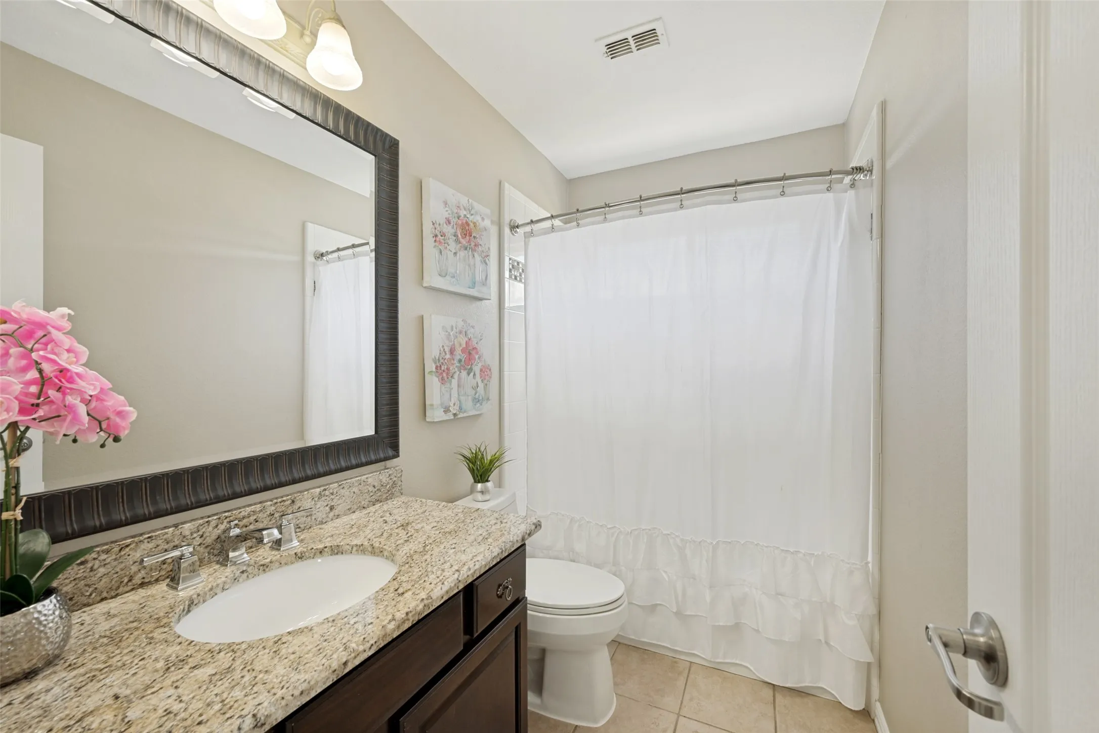 Bathroom featuring a single vanity with a light-toned granite countertop, an undermount sink, and a chrome faucet