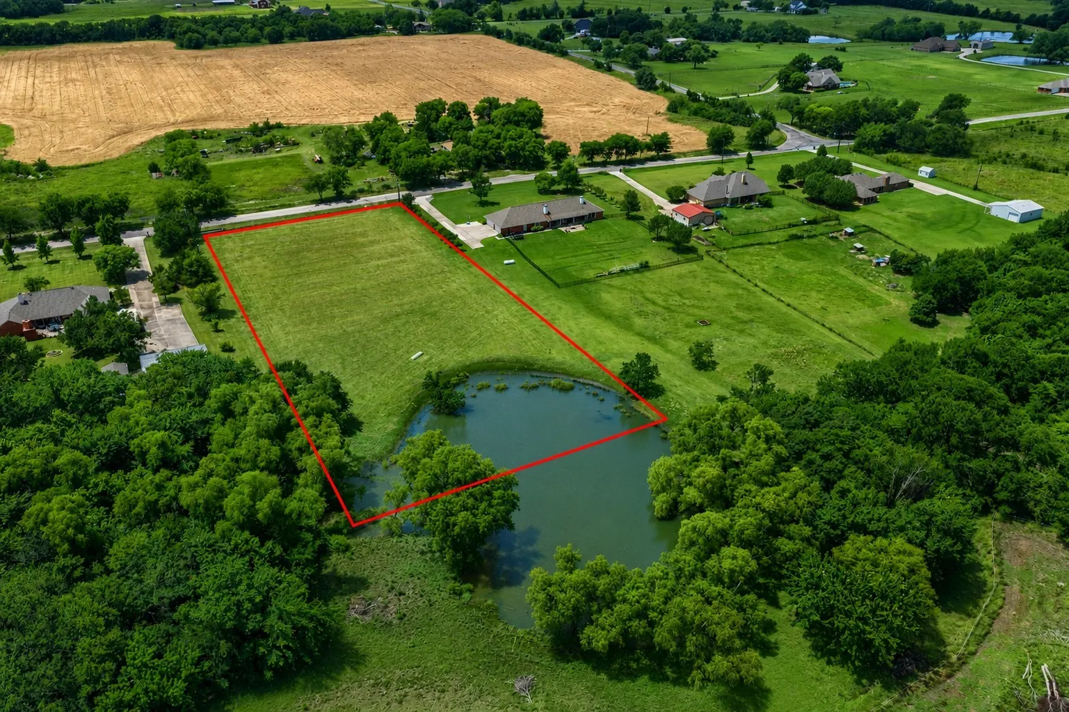 Expansive land parcel featuring a private pond and surrounding mature trees