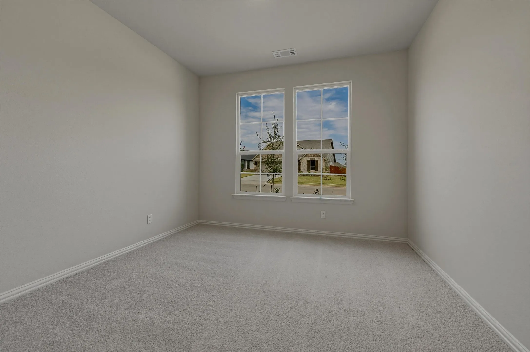 Neutral-toned walls complement the light gray carpeting