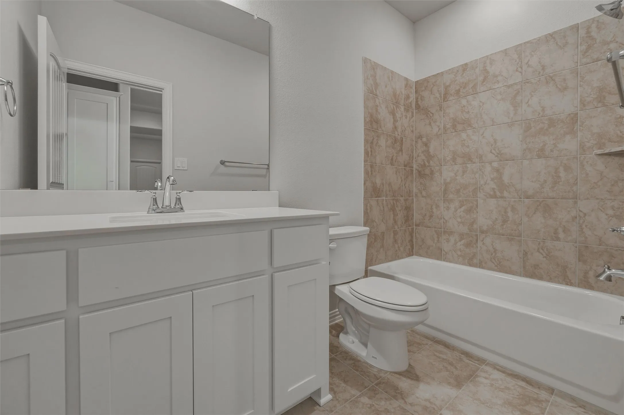 Contemporary vanity with white shaker-style cabinetry, a single basin sink, and an expansive wall-mounted mirror