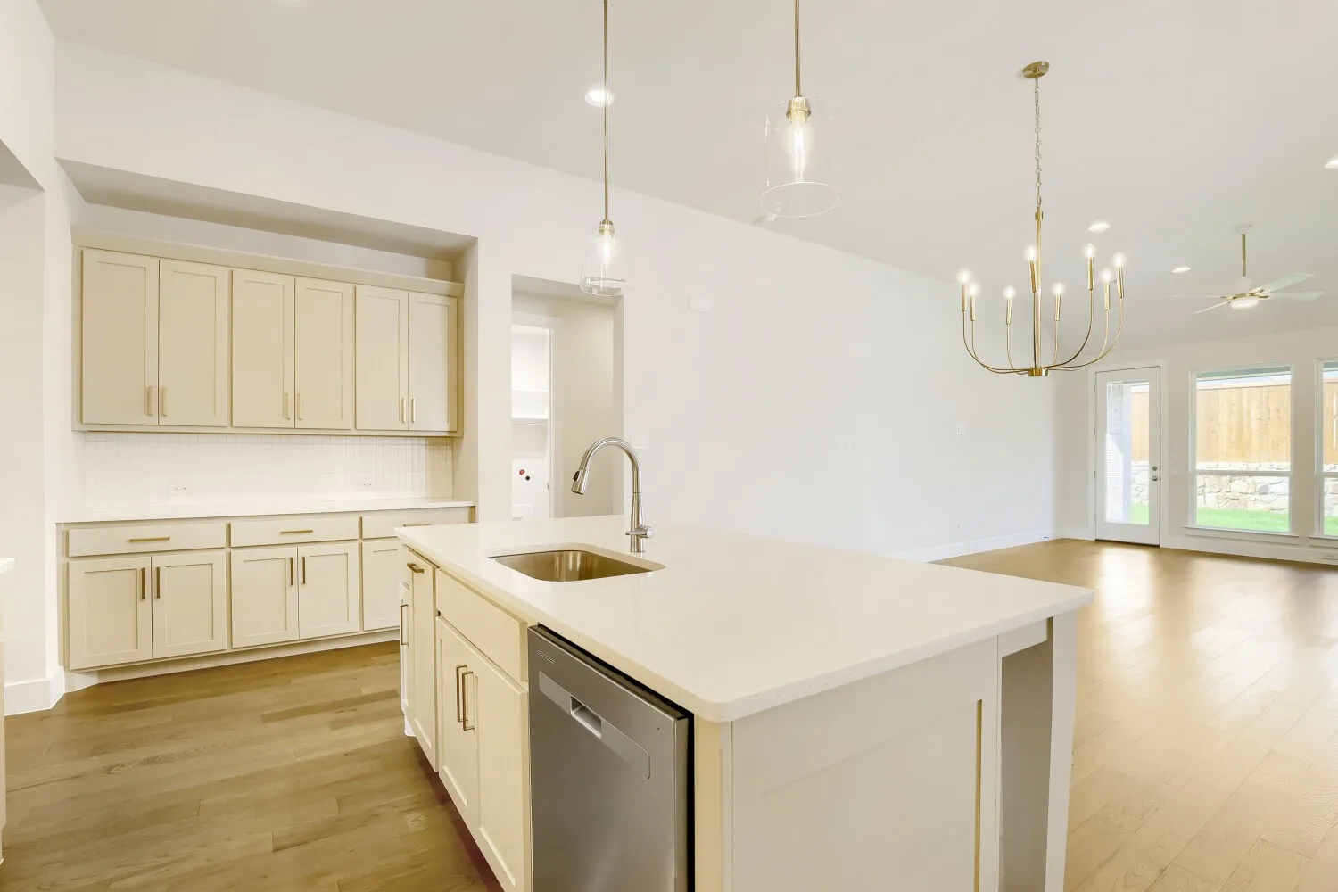 Kitchen island with an undermount sink, a stainless steel dishwasher, and a white countertop