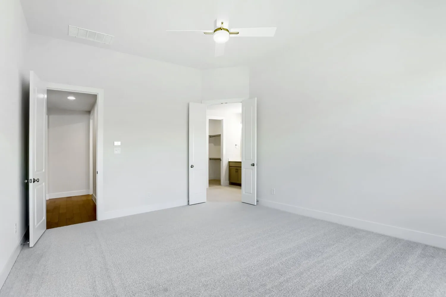 Neutral wall paint, light-colored carpeting, ceiling fan, and white trim