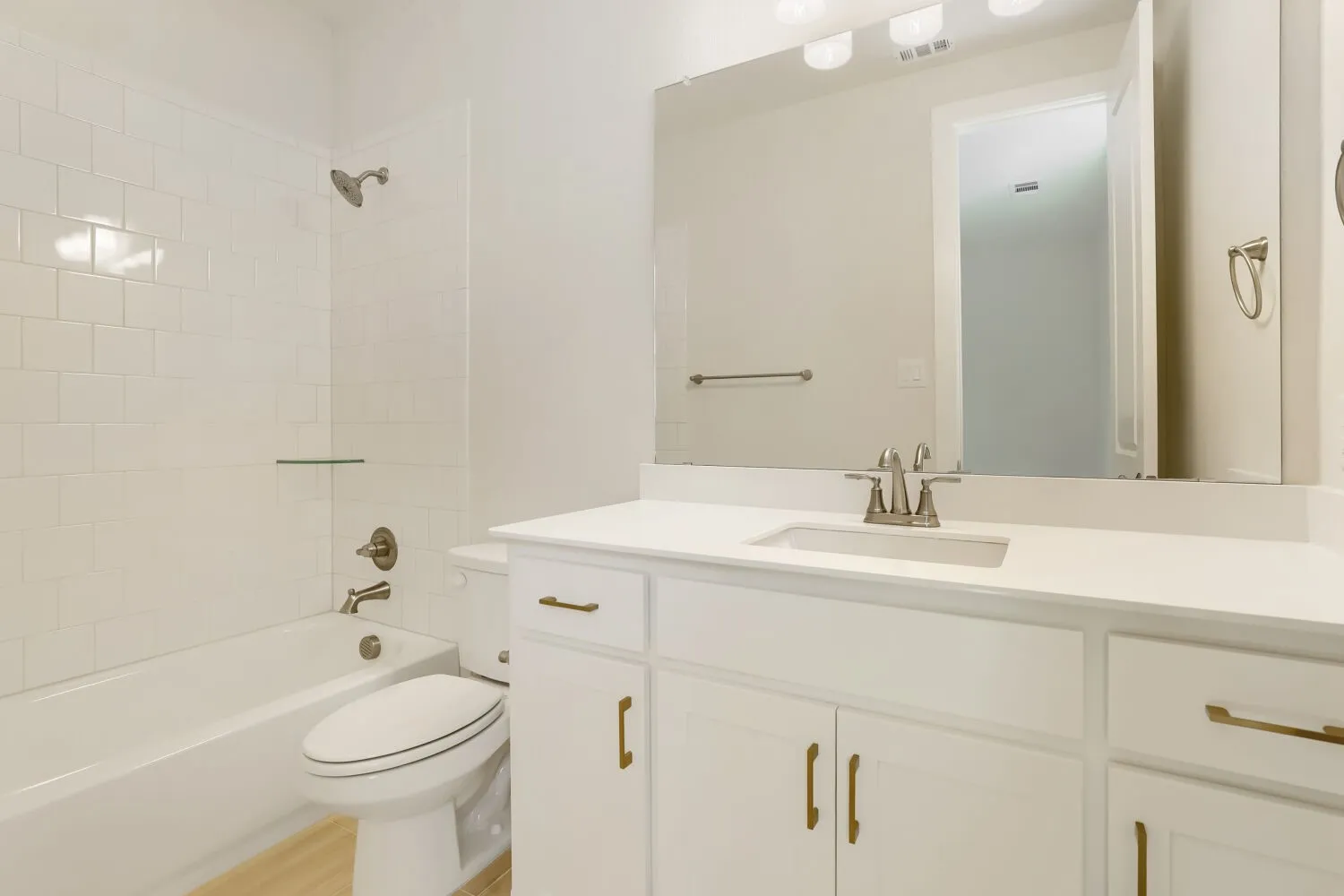 White subway tile shower surround with a built-in glass shelf