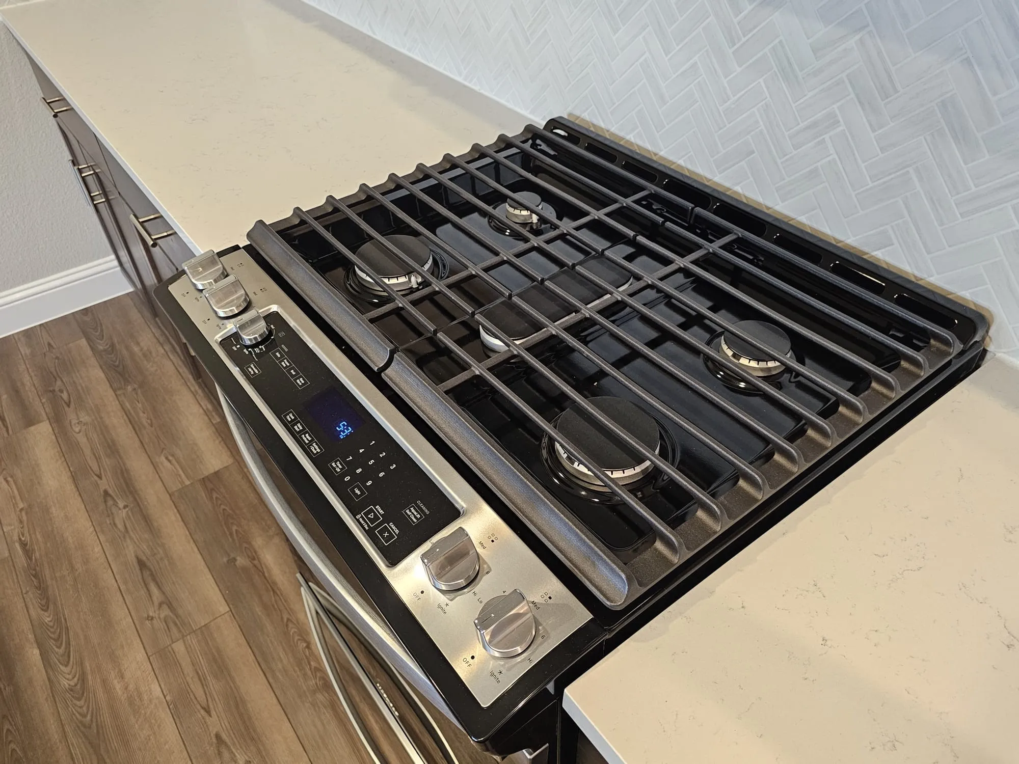 Exterior details featuring stainless steel range oven and hardwood / wood-style flooring