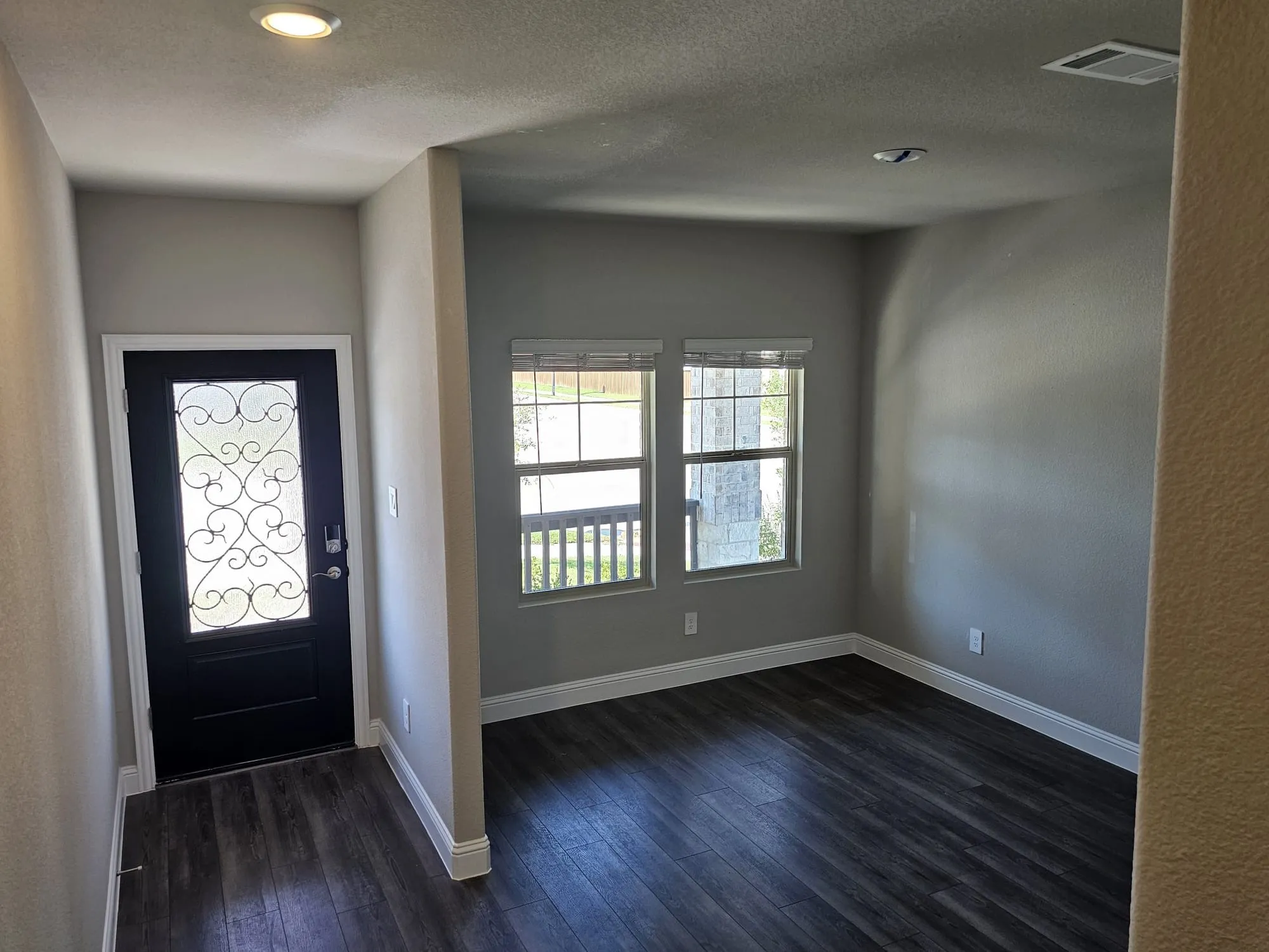Foyer entrance with a textured ceiling and dark wood-type flooring