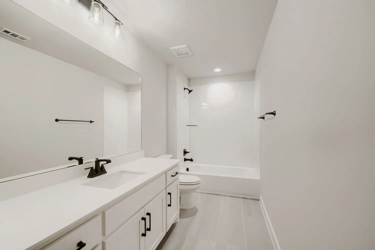 Vanity with an integrated sink, white countertop, and dark-finish hardware
