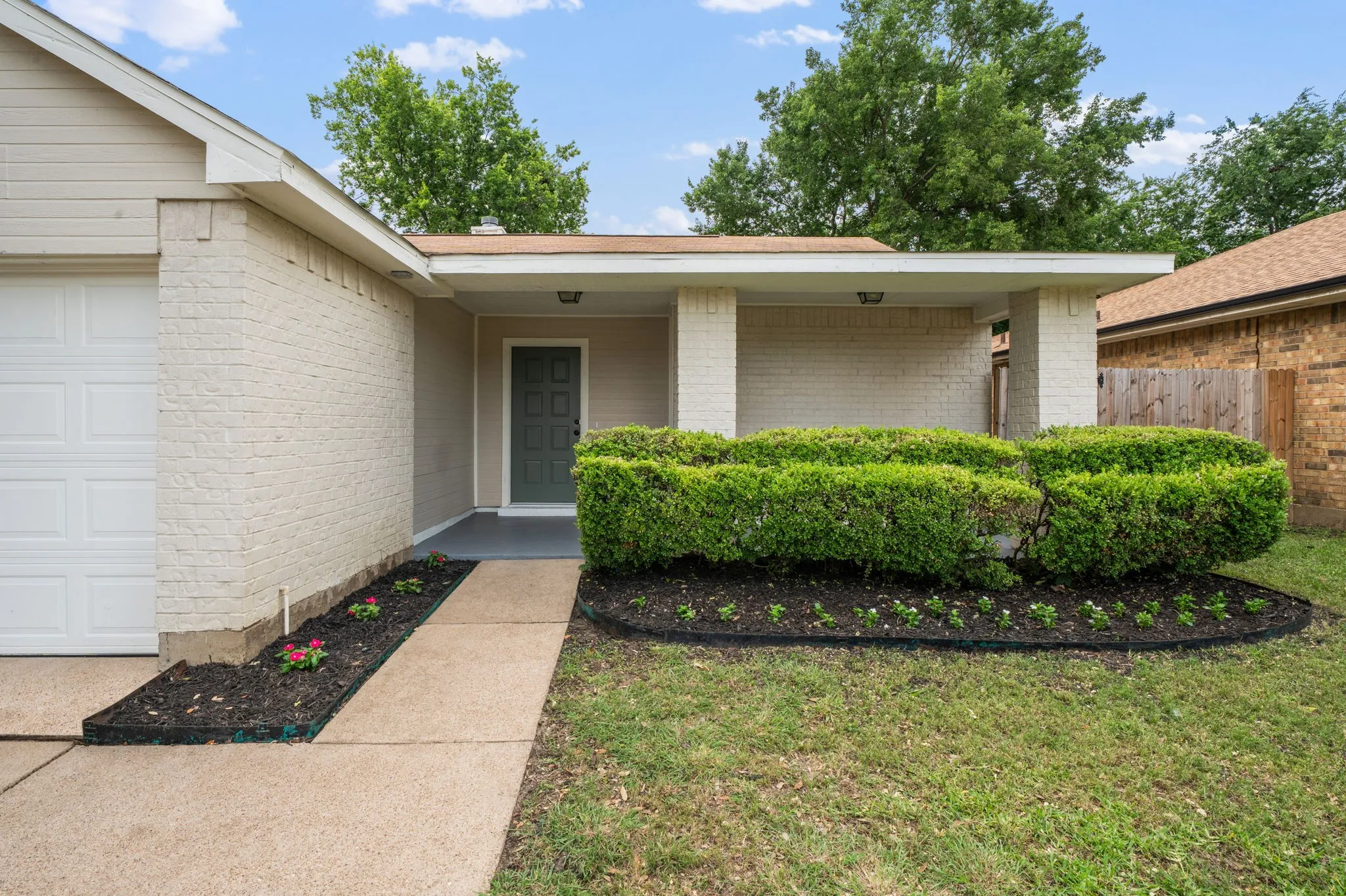 Light-colored brick exterior with a contrasting dark front door