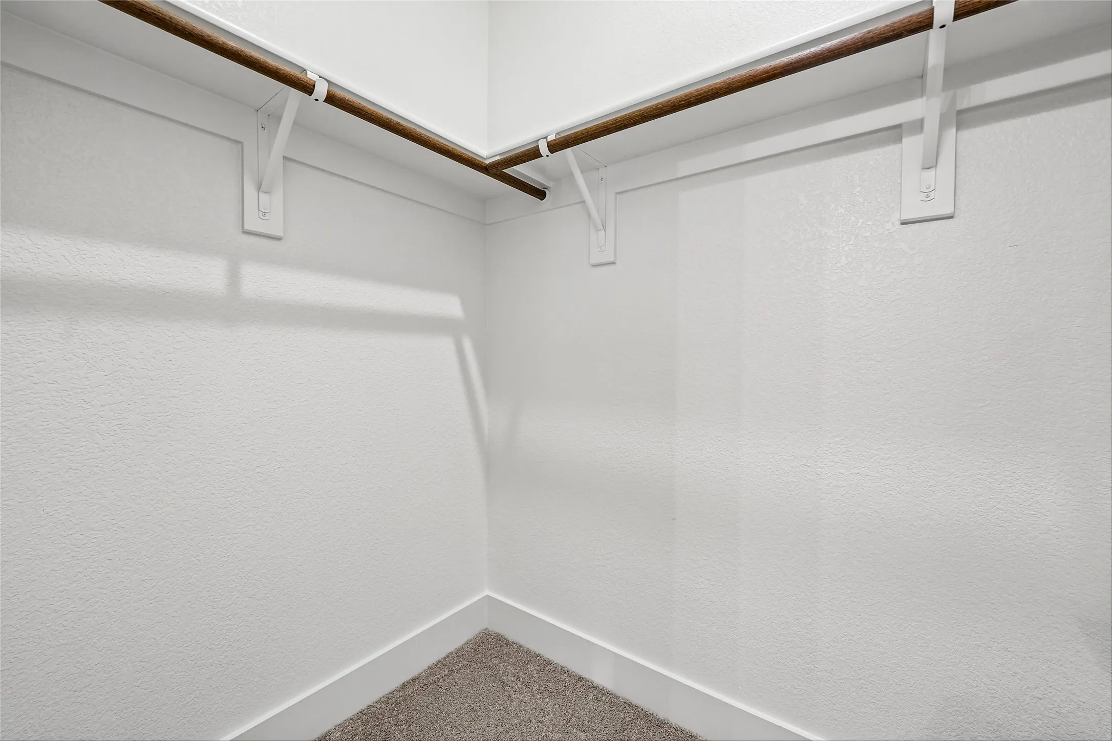 Built-in wood-finish hanging rods with white supports