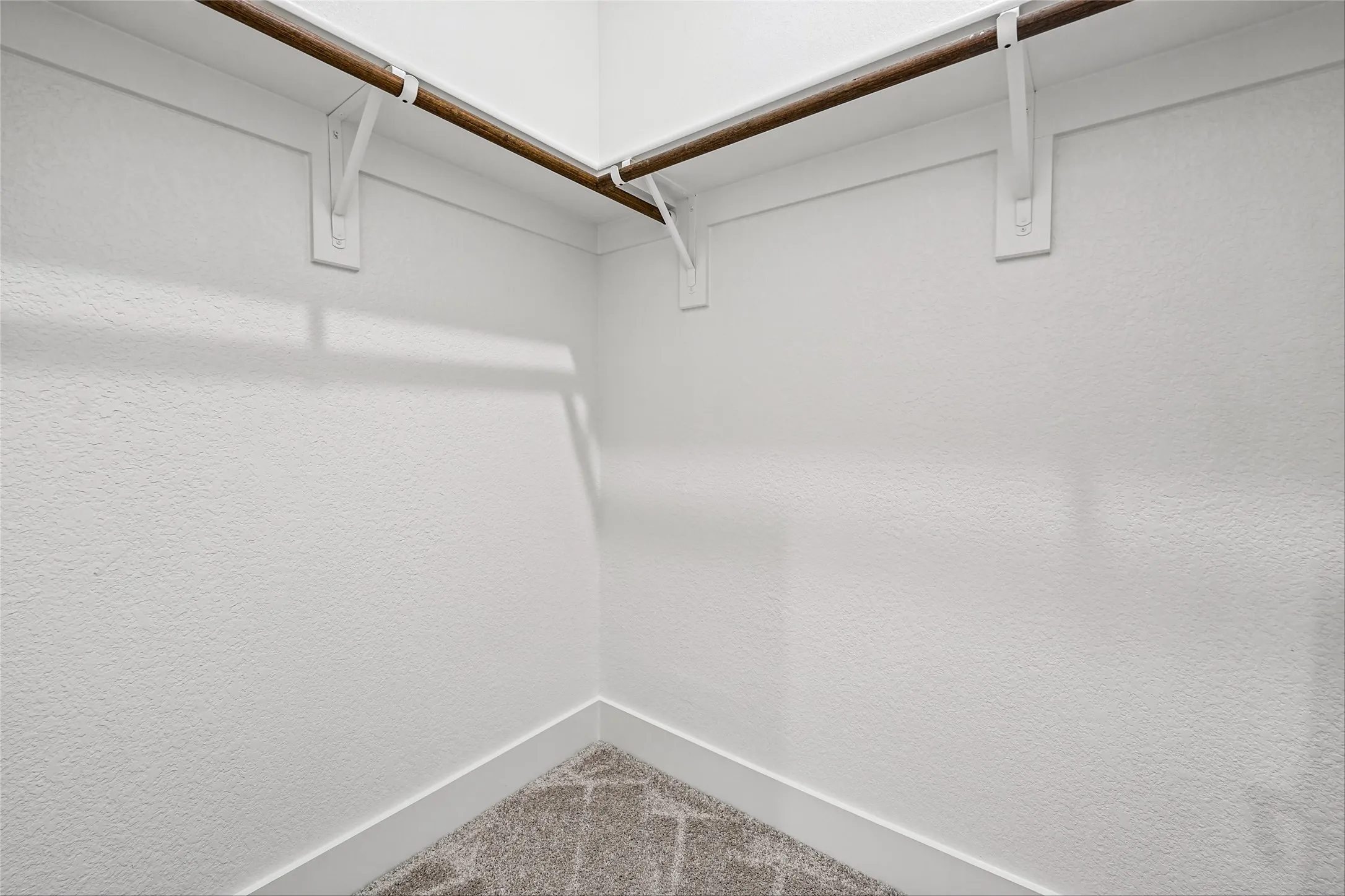 Built-in closet rods with white support brackets