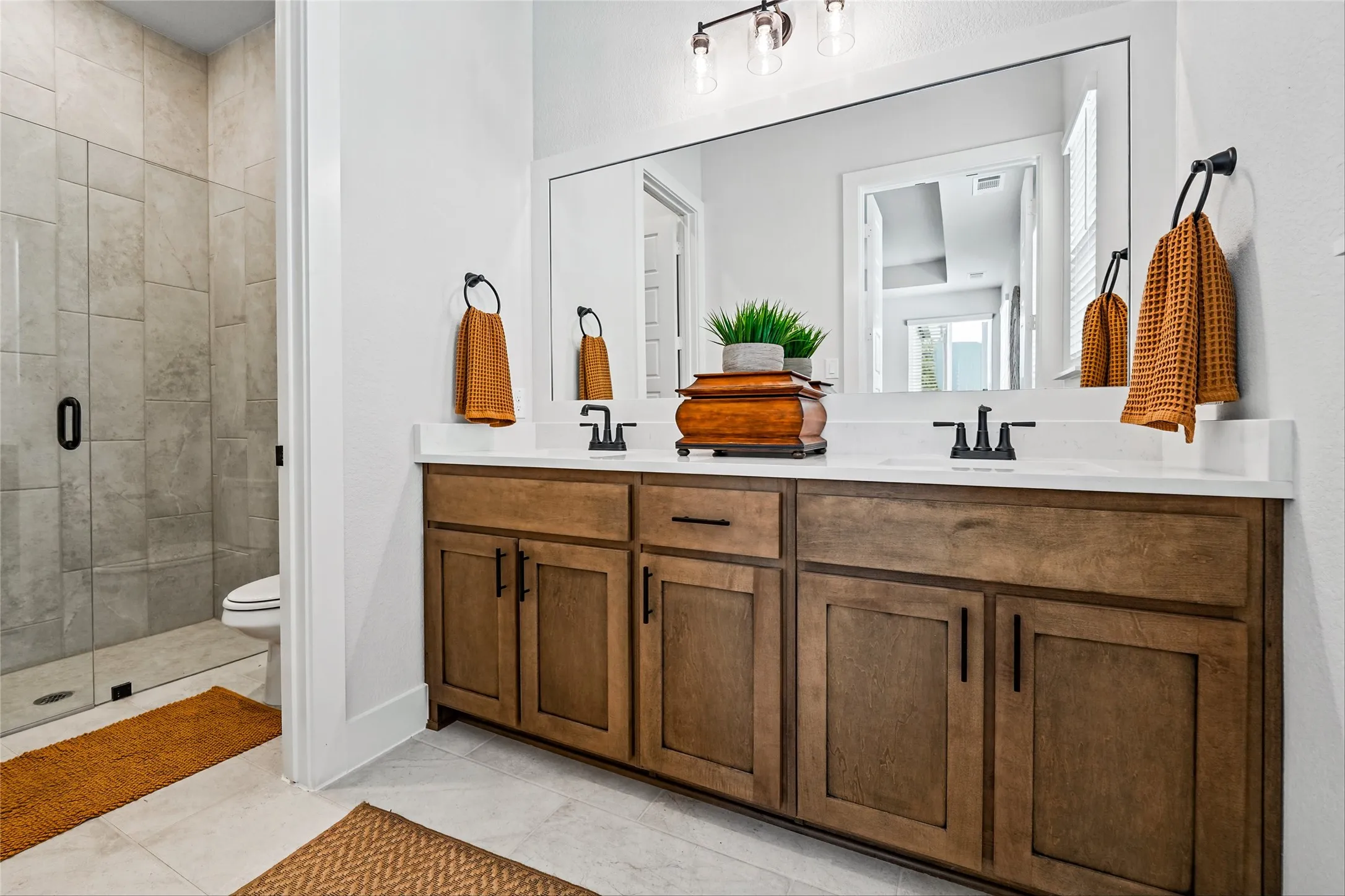 Dual vanity with wood-finish cabinetry, white countertop, and rectangular undermount sinks