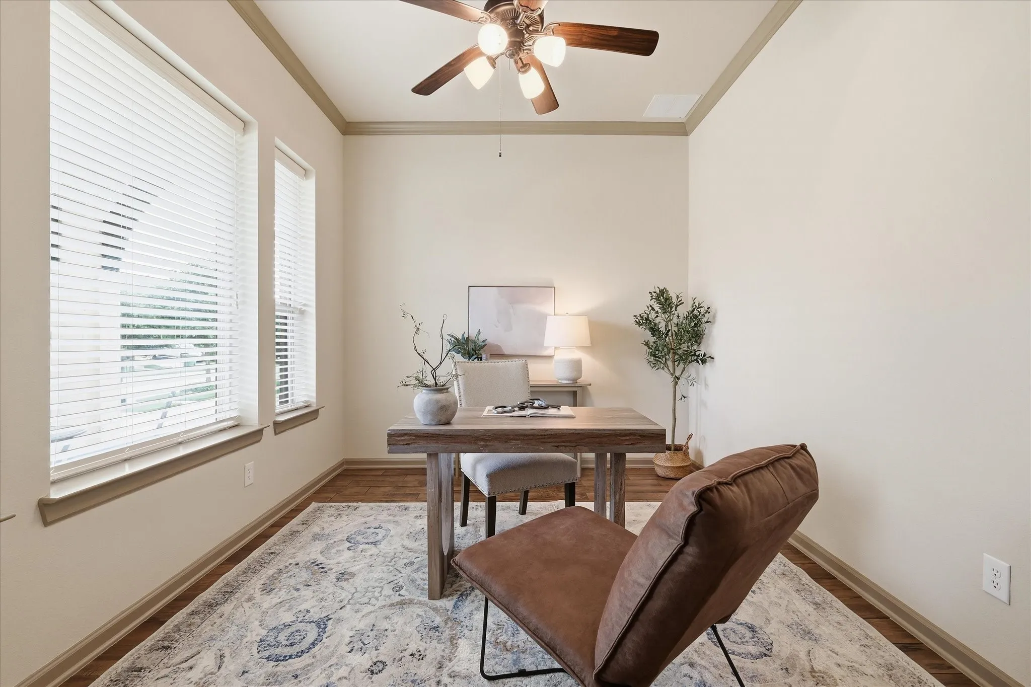 Spacious room featuring large windows with blinds, crown molding, a ceiling fan with integrated lighting, and wood-finish tile flooring