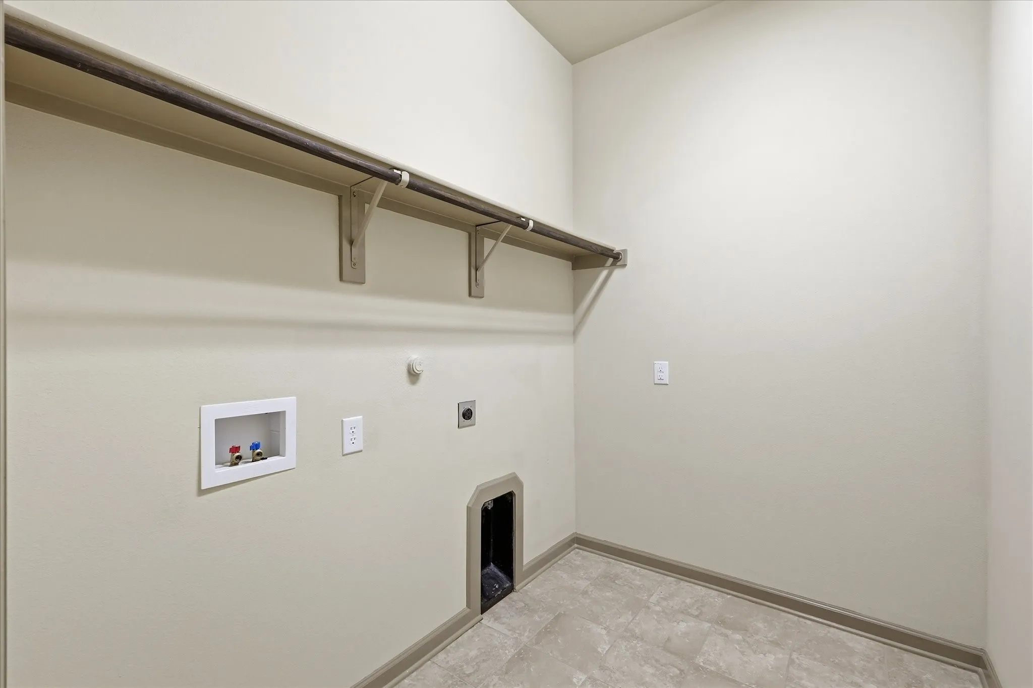 Utility room featuring an elevated shelf with hanging rod, vinyl flooring, and neutral wall paint