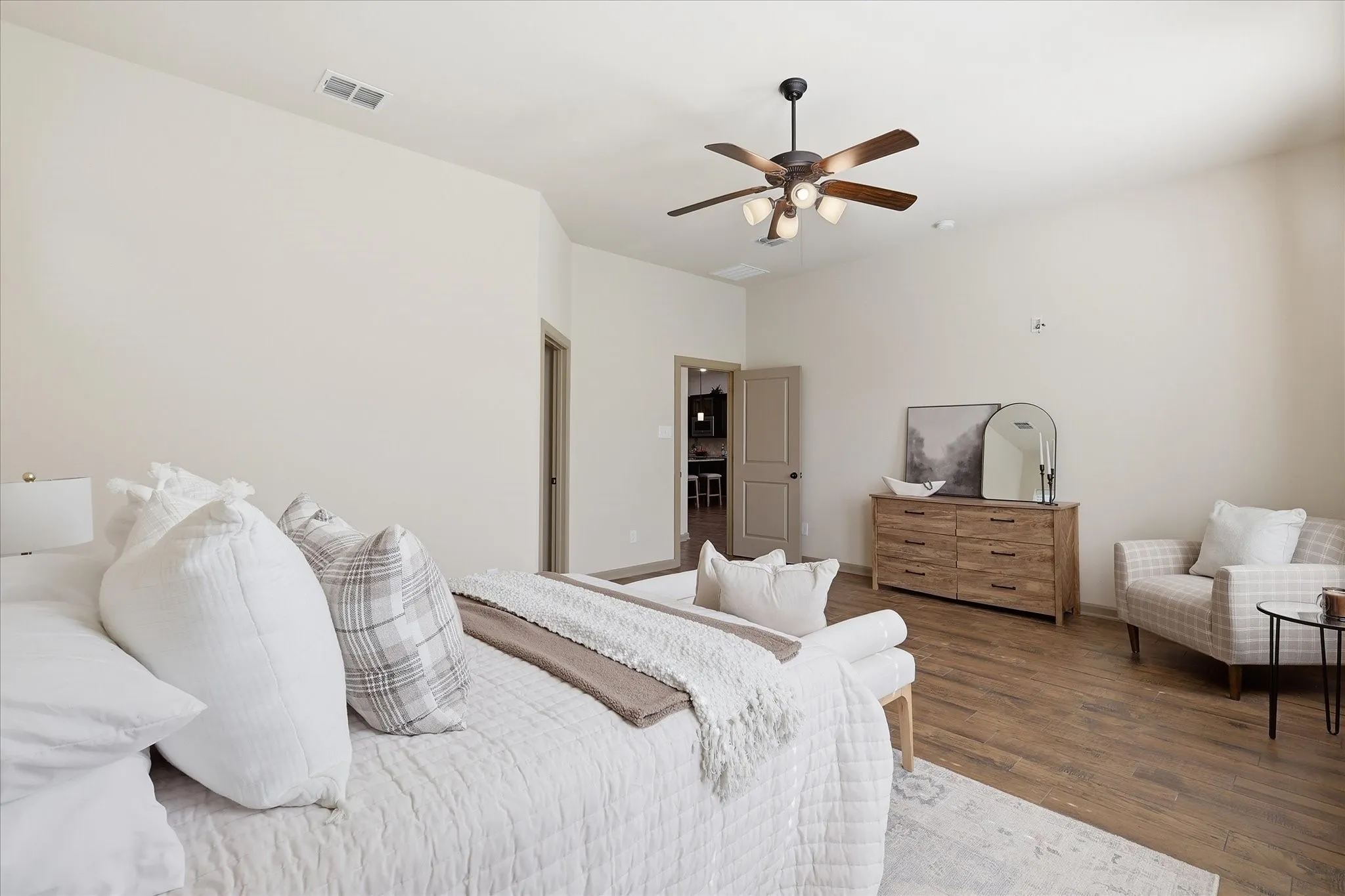 Spacious room featuring vaulted ceilings, wood-finish flooring, a contemporary ceiling fan with integrated lighting, and neutral wall tones