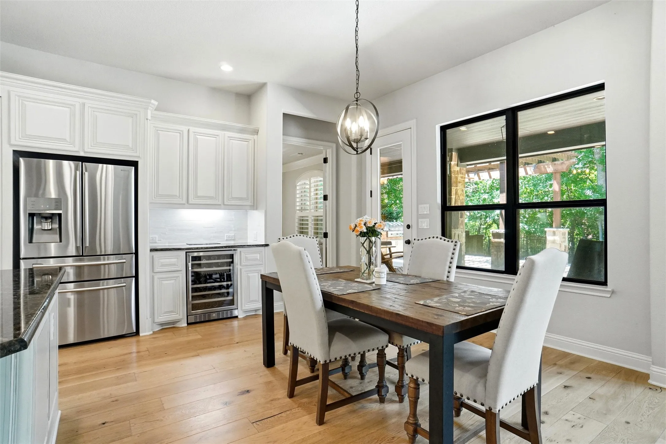 Dining area featuring light wood-finish flooring and a contemporary chandelier