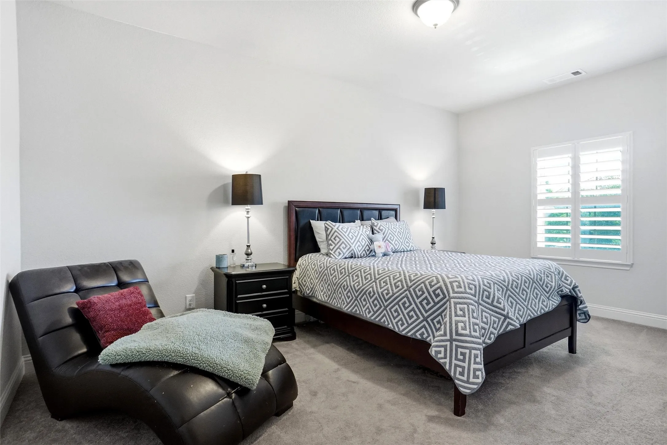 Neutral wall paint, light gray carpeting, and a ceiling-mounted light fixture