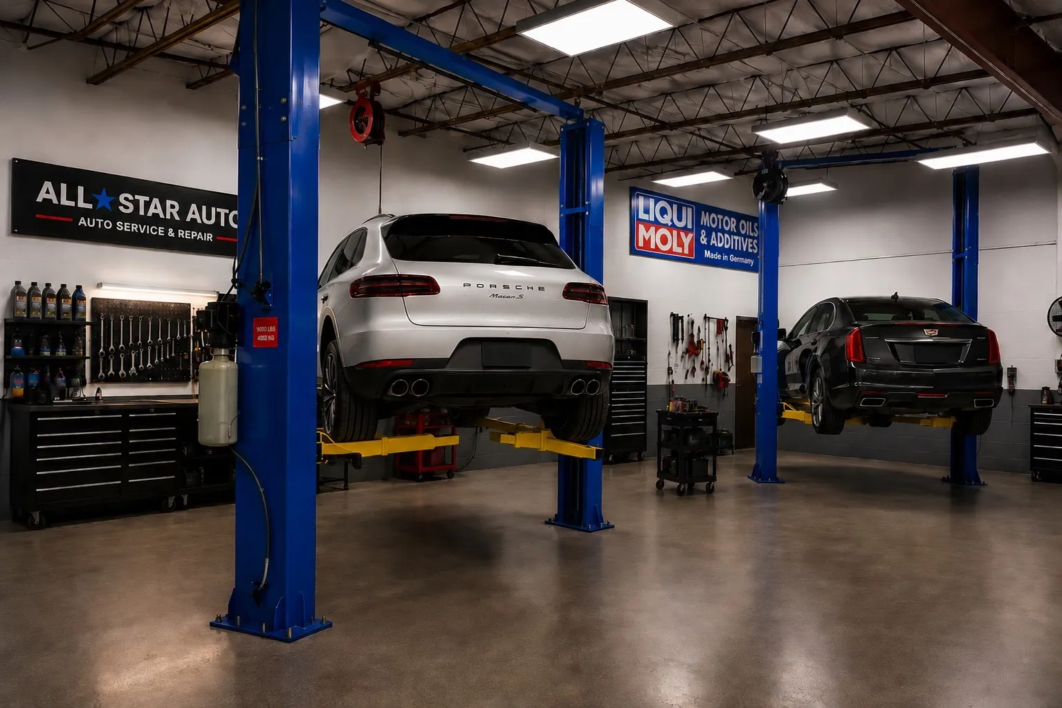 Industrial garage space featuring two vehicle lifts, polished concrete flooring, and ample overhead lighting