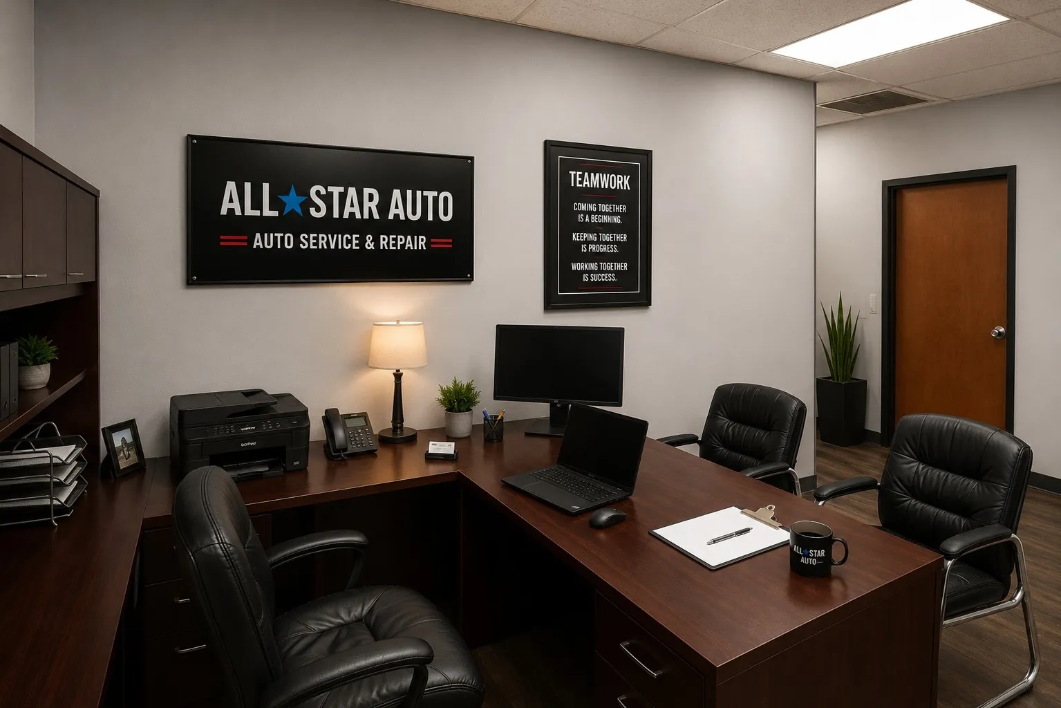 Dedicated office space featuring a large wood-finish L-shaped desk, built-in overhead cabinetry, light gray walls, wood-finish flooring, and recessed ceiling lighting