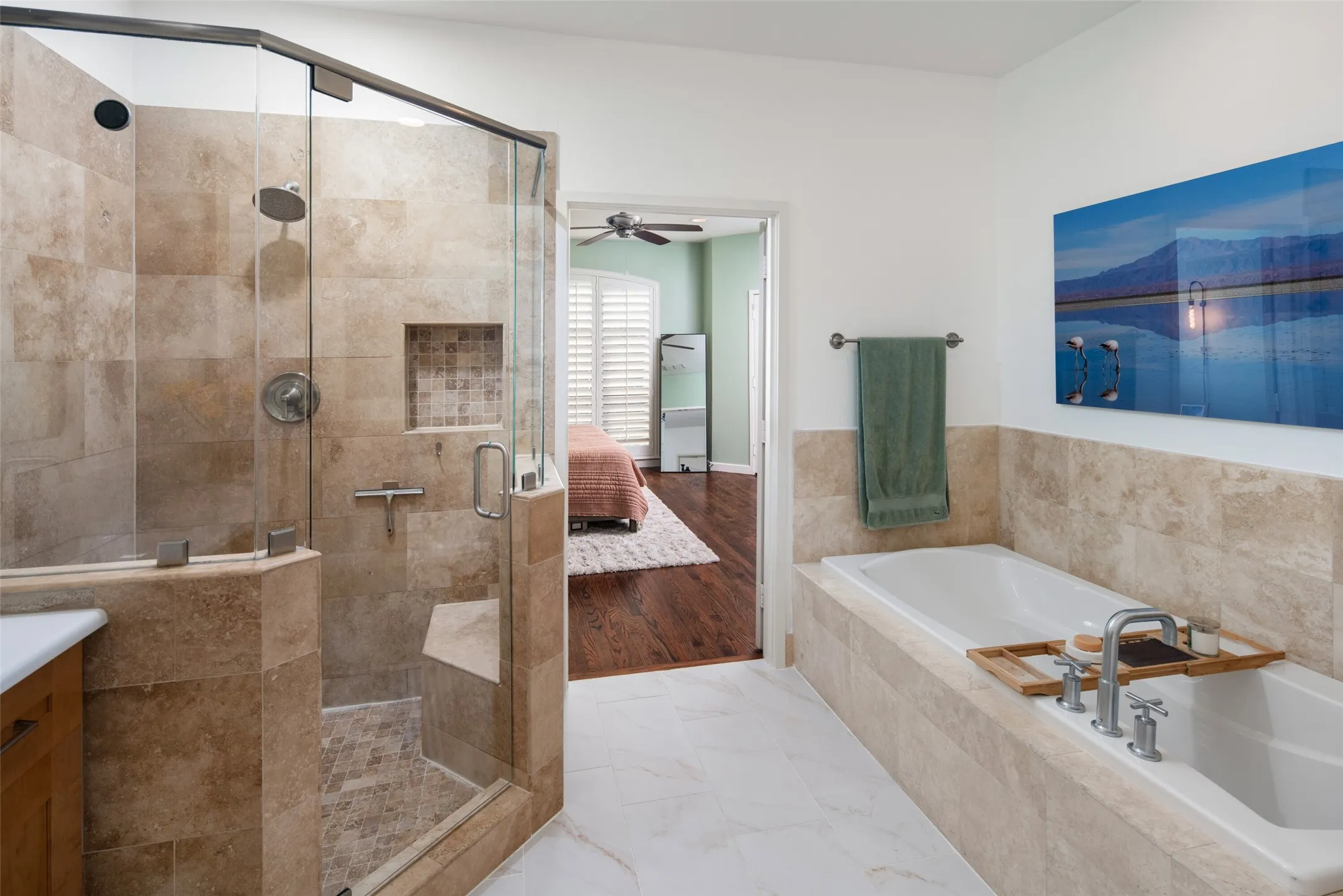 Walk-in shower with clear glass enclosure and integrated bench seating, complemented by floor-to-ceiling tile work