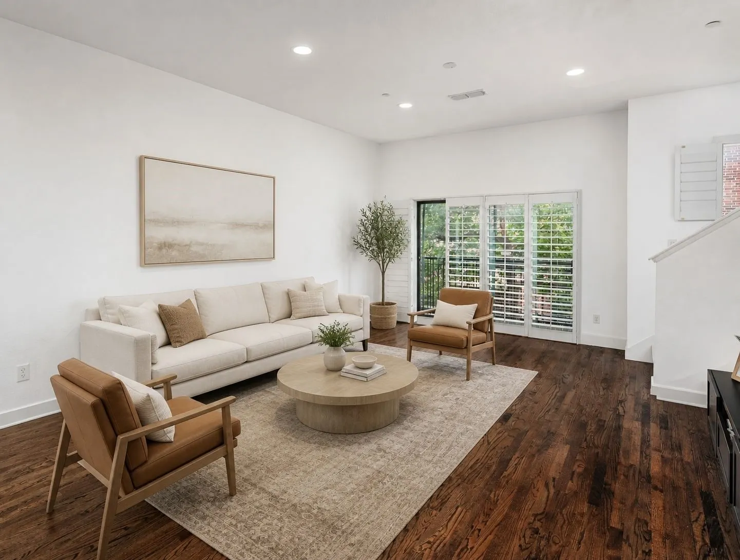Recessed lighting, wood-finish flooring, white walls, and a glass-paneled door with white plantation shutters