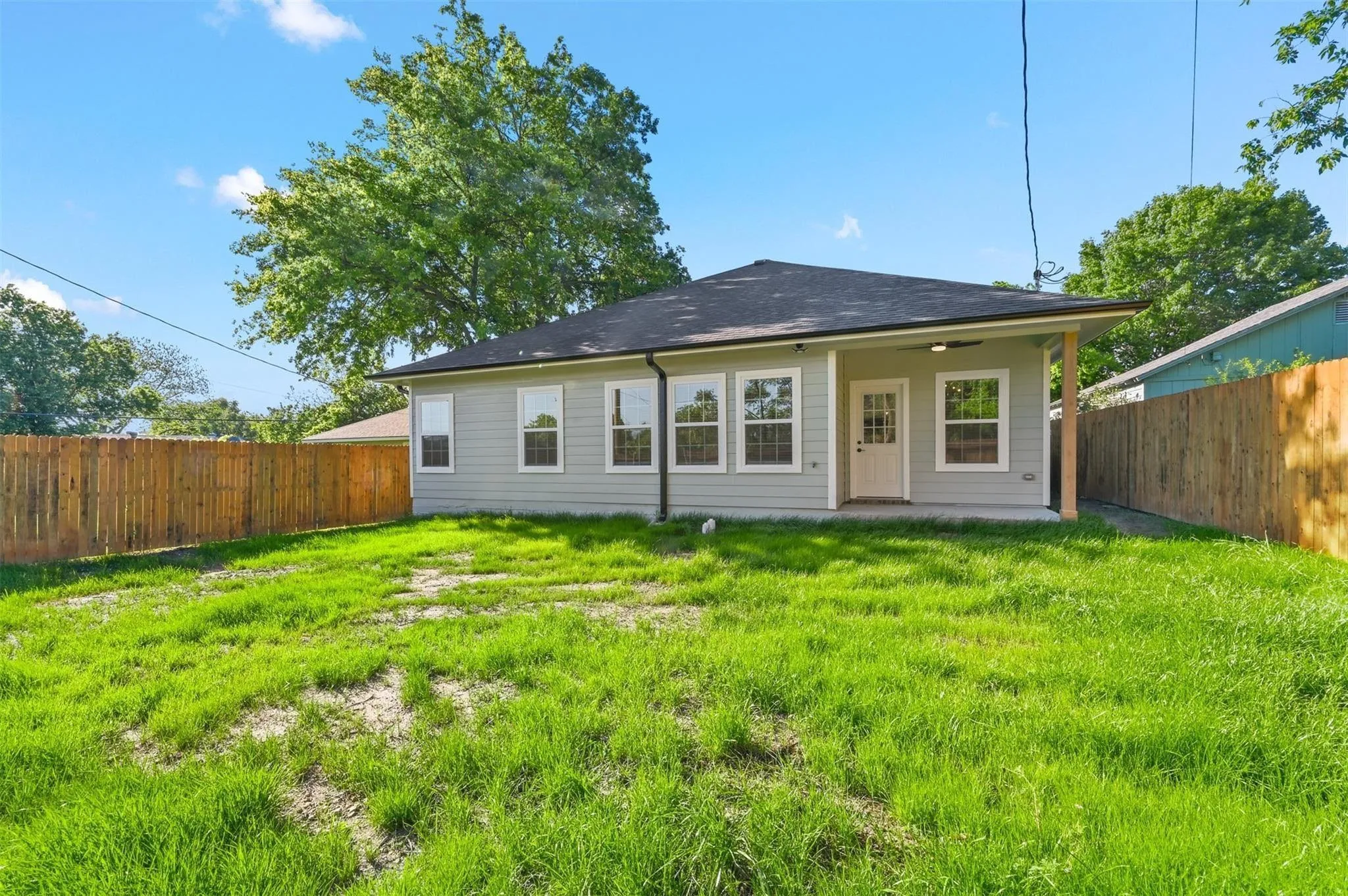 Spacious backyard featuring a newly installed wooden privacy fence
