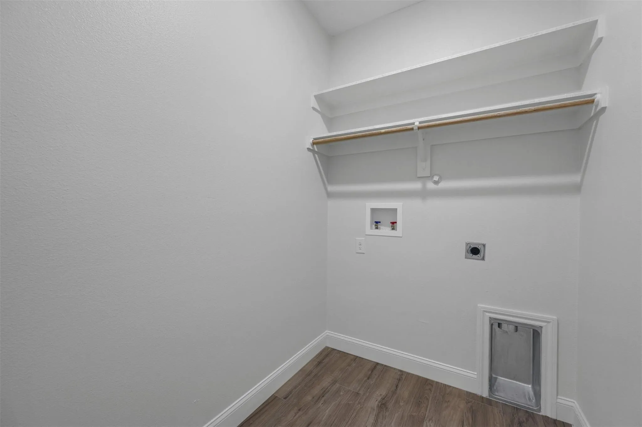Dedicated laundry alcove with wood-finish flooring