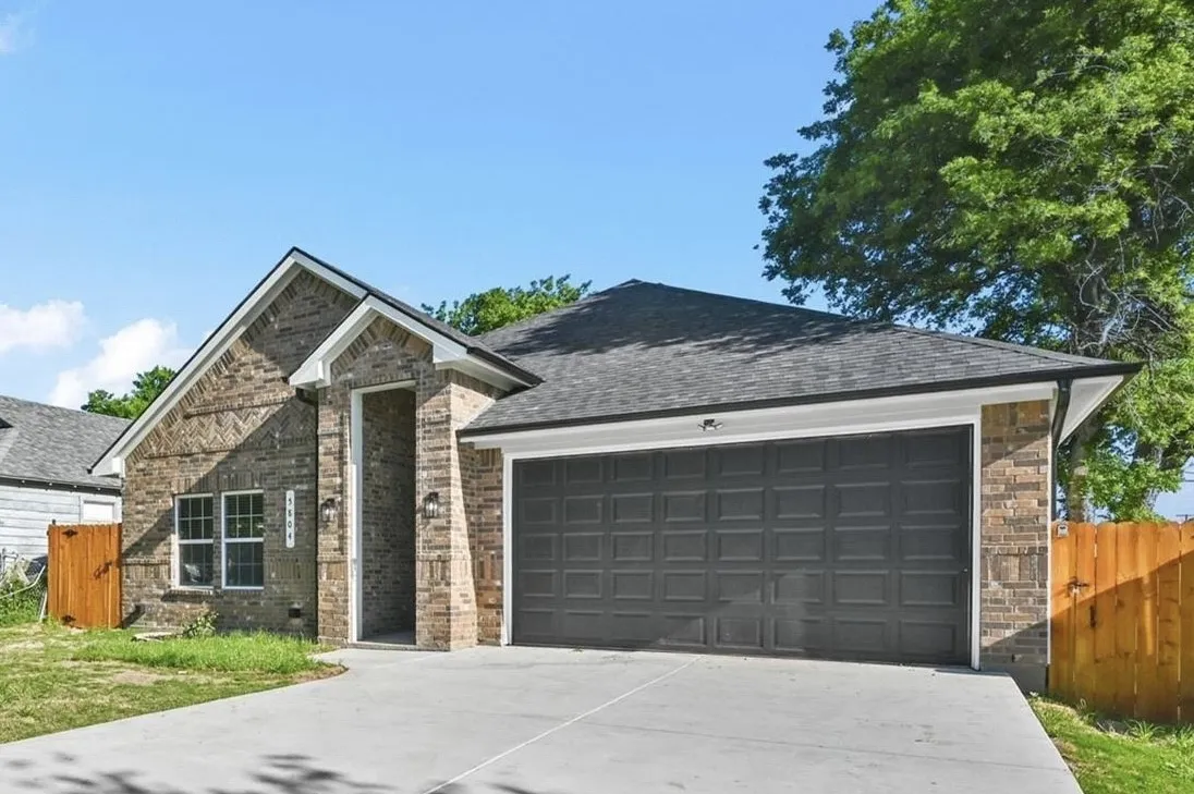 Brick facade home featuring a prominent two-car garage