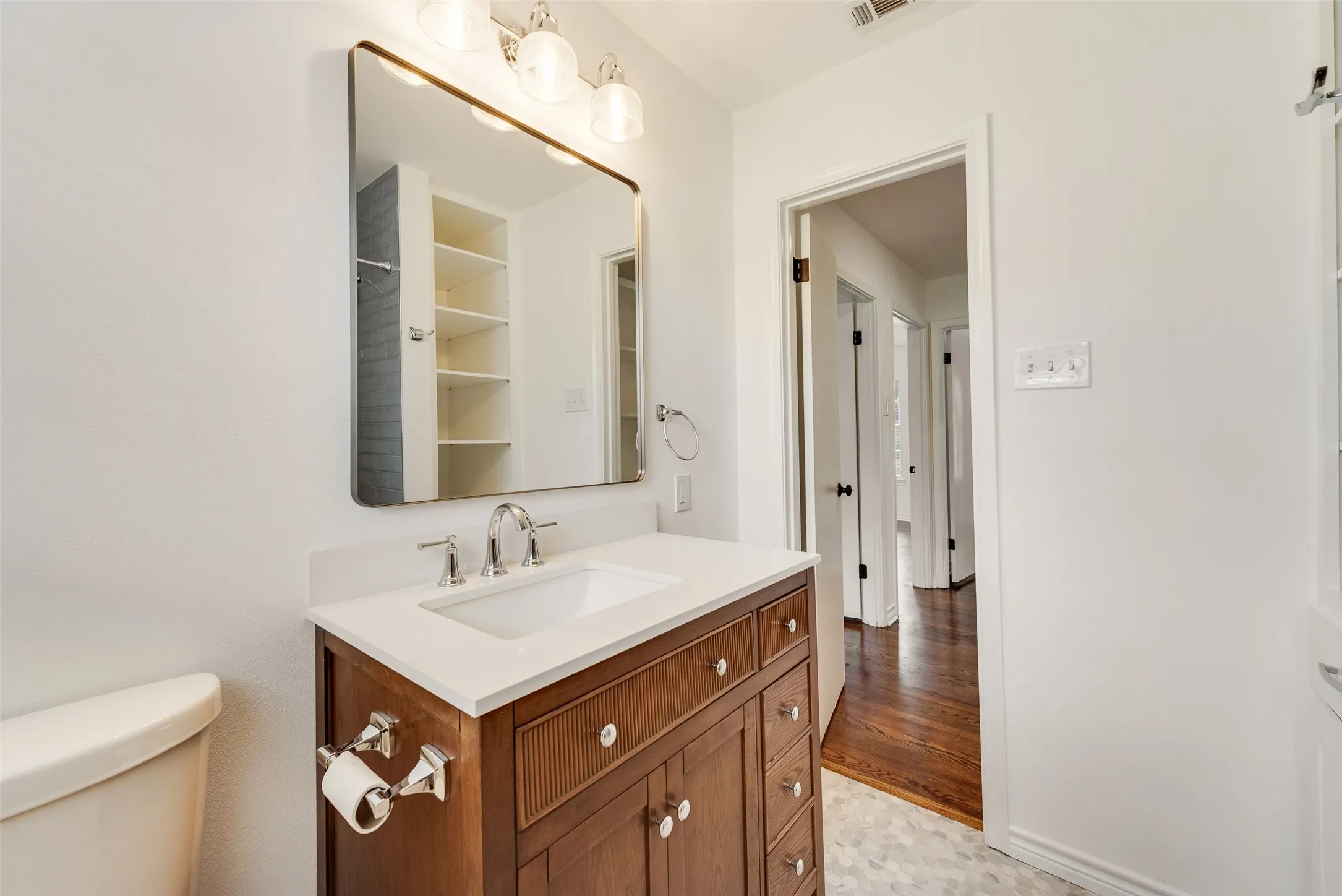 Bathroom vanity with a white countertop, undermount sink, and chrome fixtures