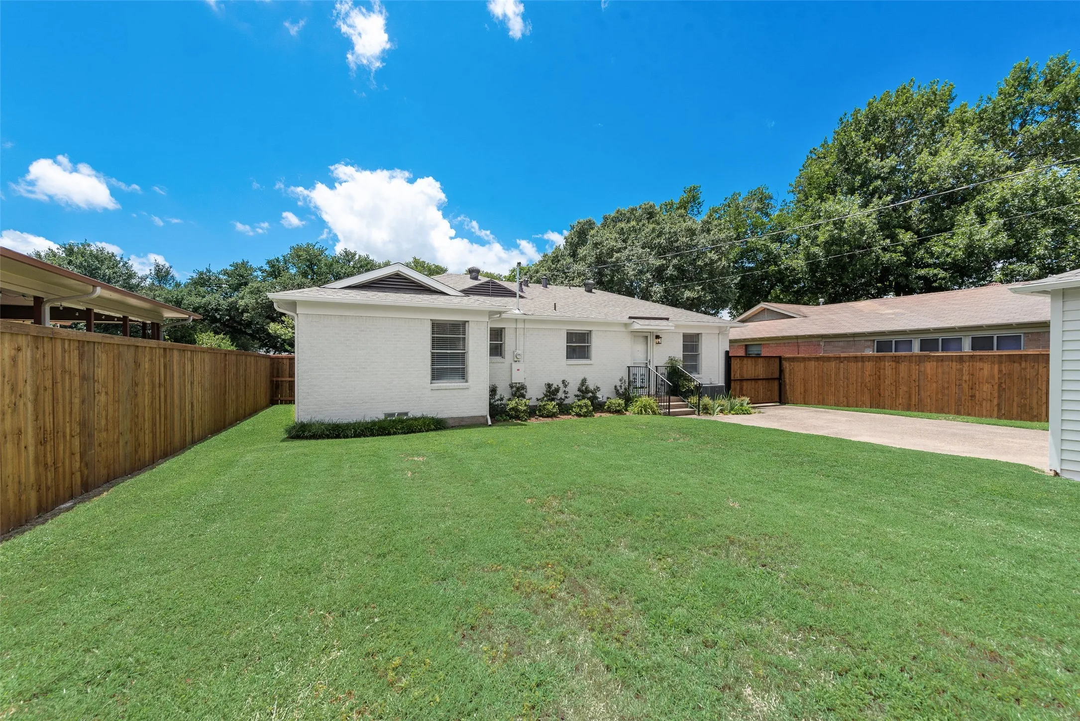 Expansive grass lawn bordered by a wood privacy fence