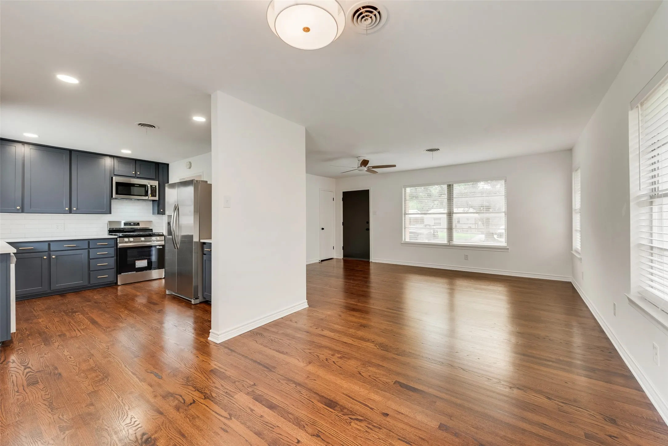 Open-concept living area and kitchen featuring wood-finish flooring