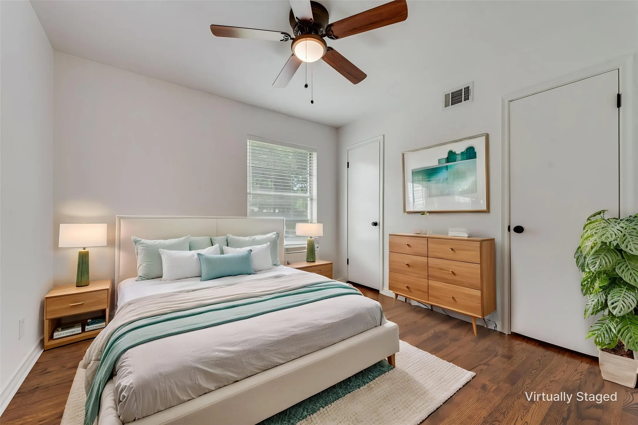 Bedroom featuring wood-finish flooring, white walls, and a ceiling fan with light fixture