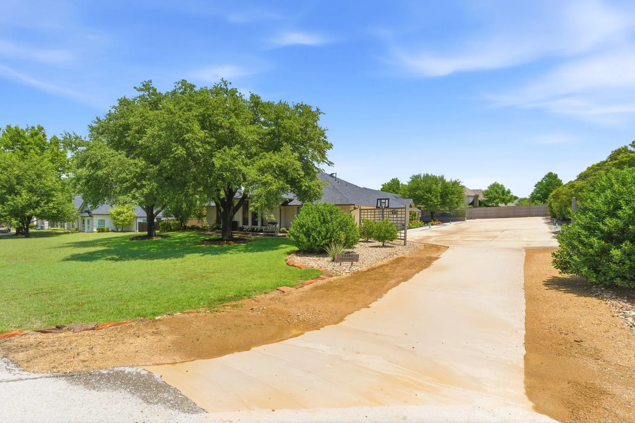 long driveway leading to expansive paved parking area for vehicles, toys and rv