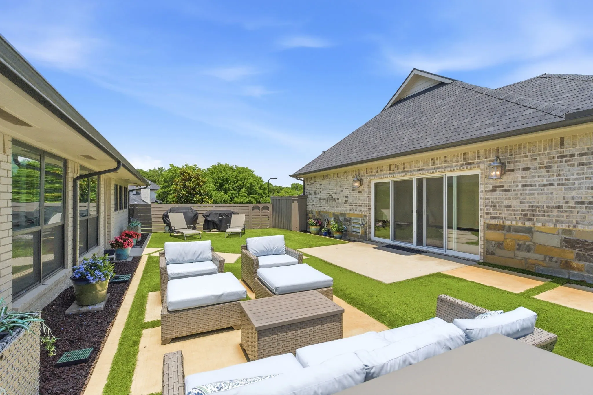 turfed patio area between the main house and indoor pool house