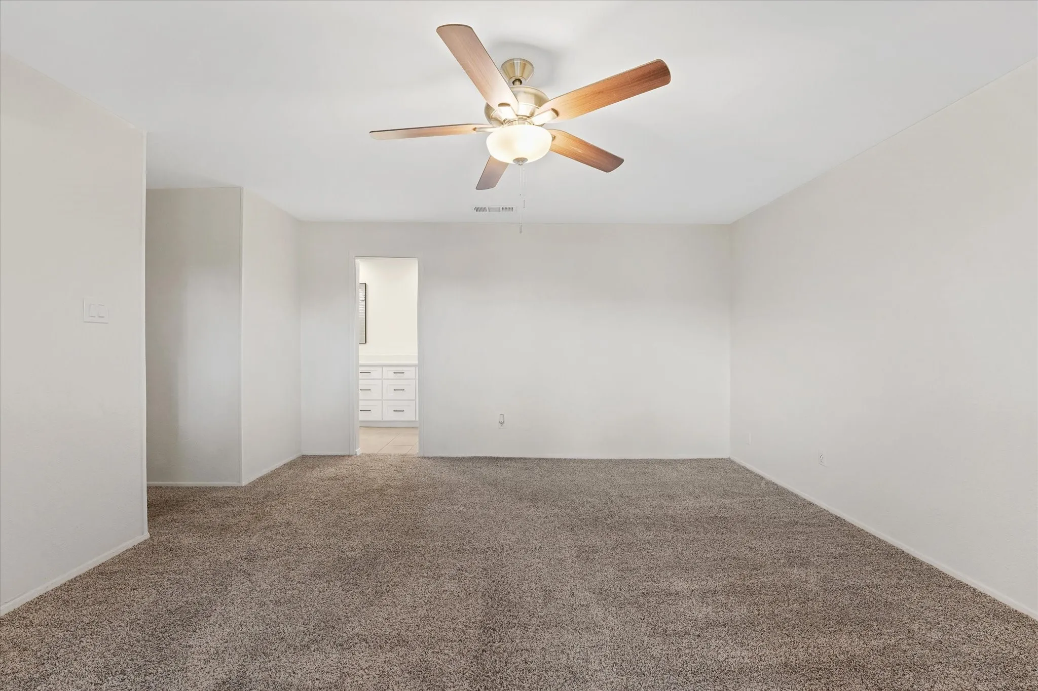 Spacious room featuring neutral carpeting and light-toned walls