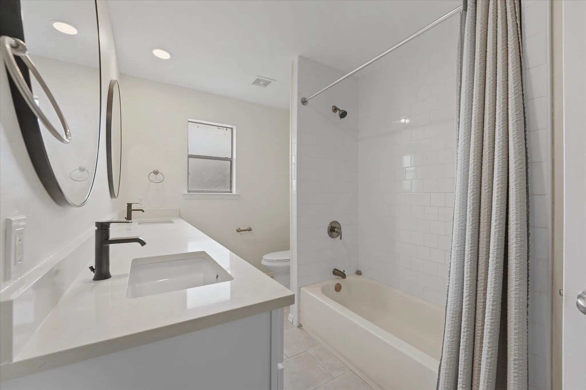 Bathroom featuring a double vanity with integrated rectangular sinks, white quartz countertops, and matte black fixtures