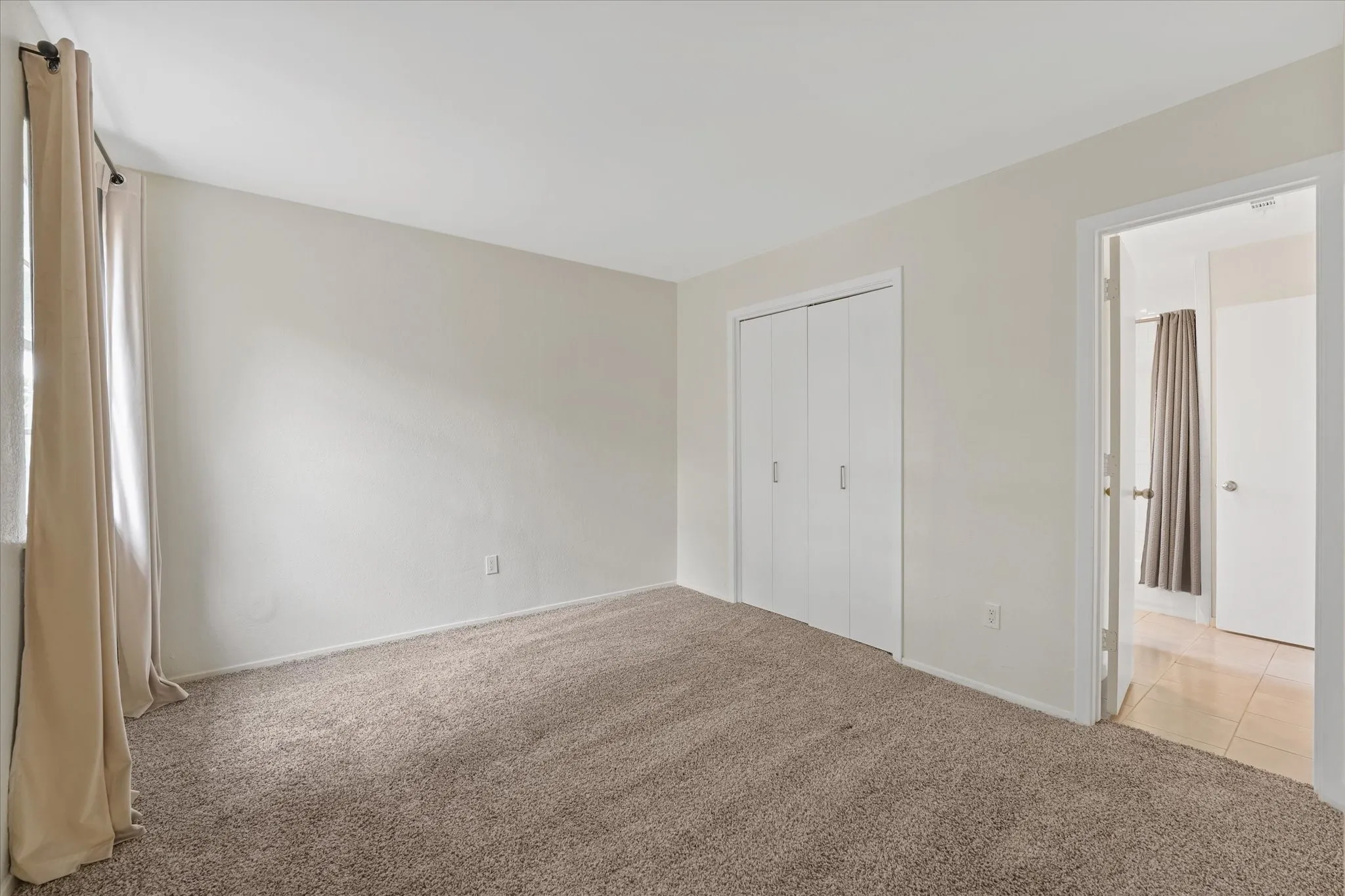 Neutral-toned wall paint and plush carpeting create a versatile interior