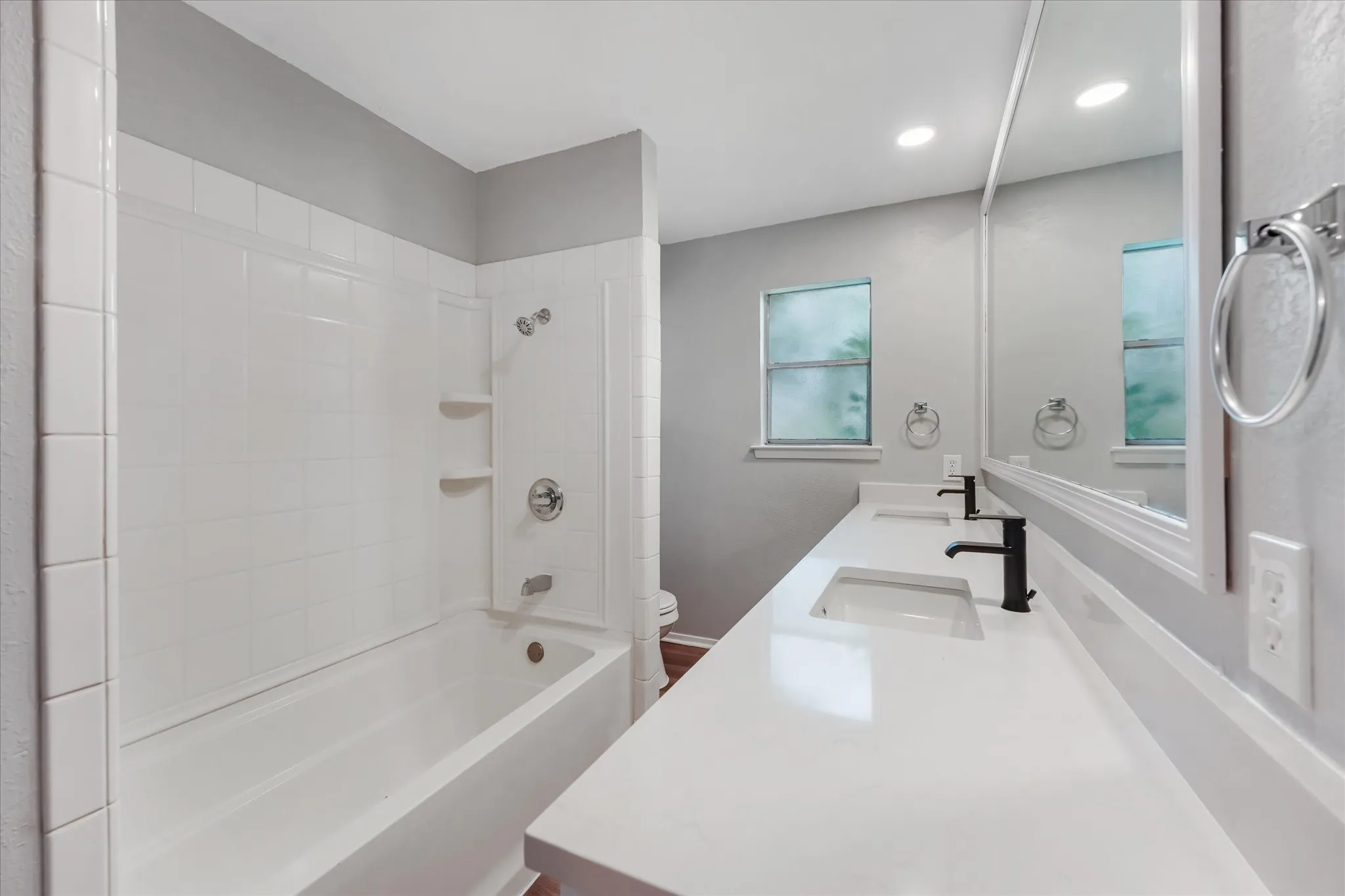 Bathroom featuring a double vanity with white countertops, dual rectangular sinks, and matte black faucets