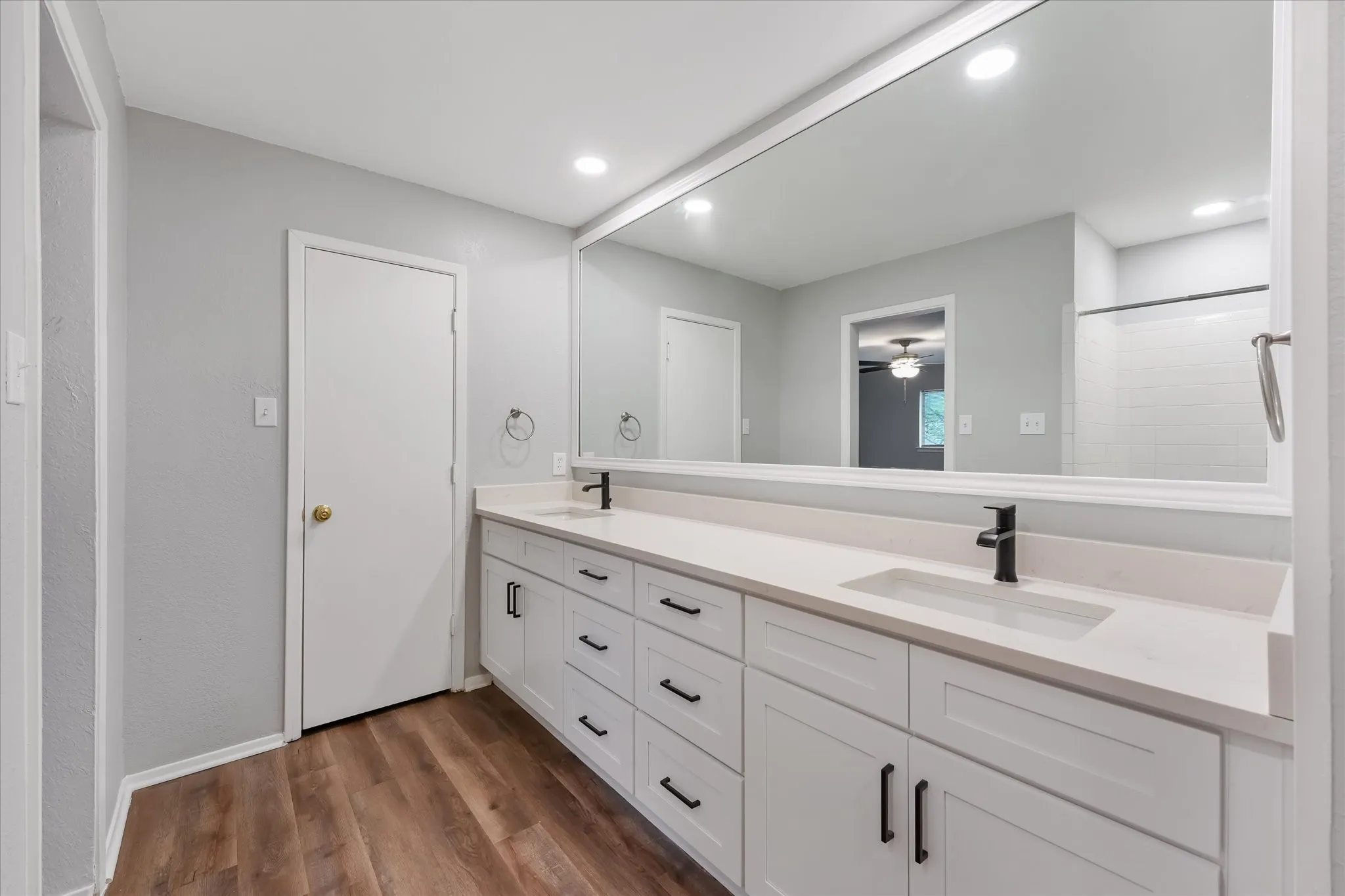 Dual vanity with white cabinetry, matte black hardware, and integrated sinks