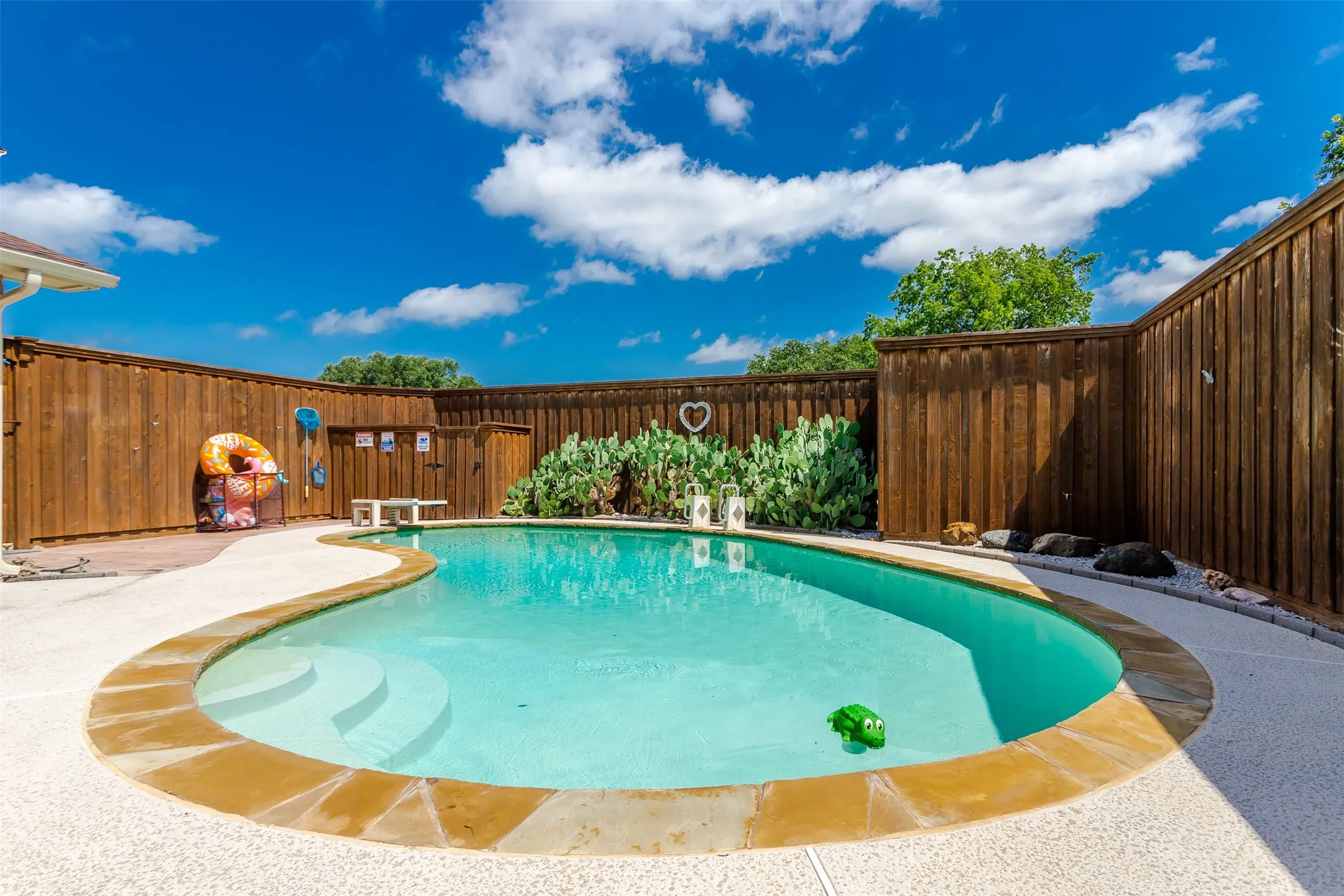 Curved swimming pool with broad steps and a flagstone coping