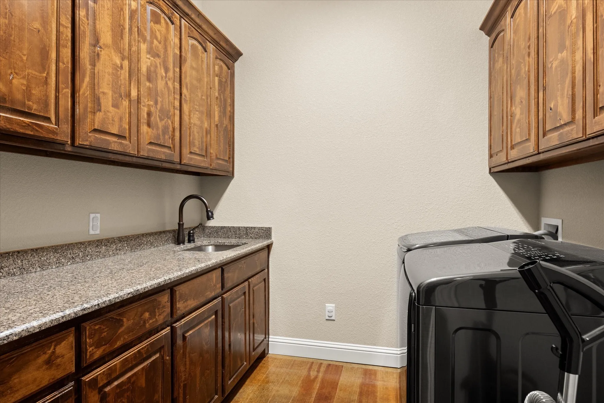 Large laundry room with ample cabinet storage and hanging space.