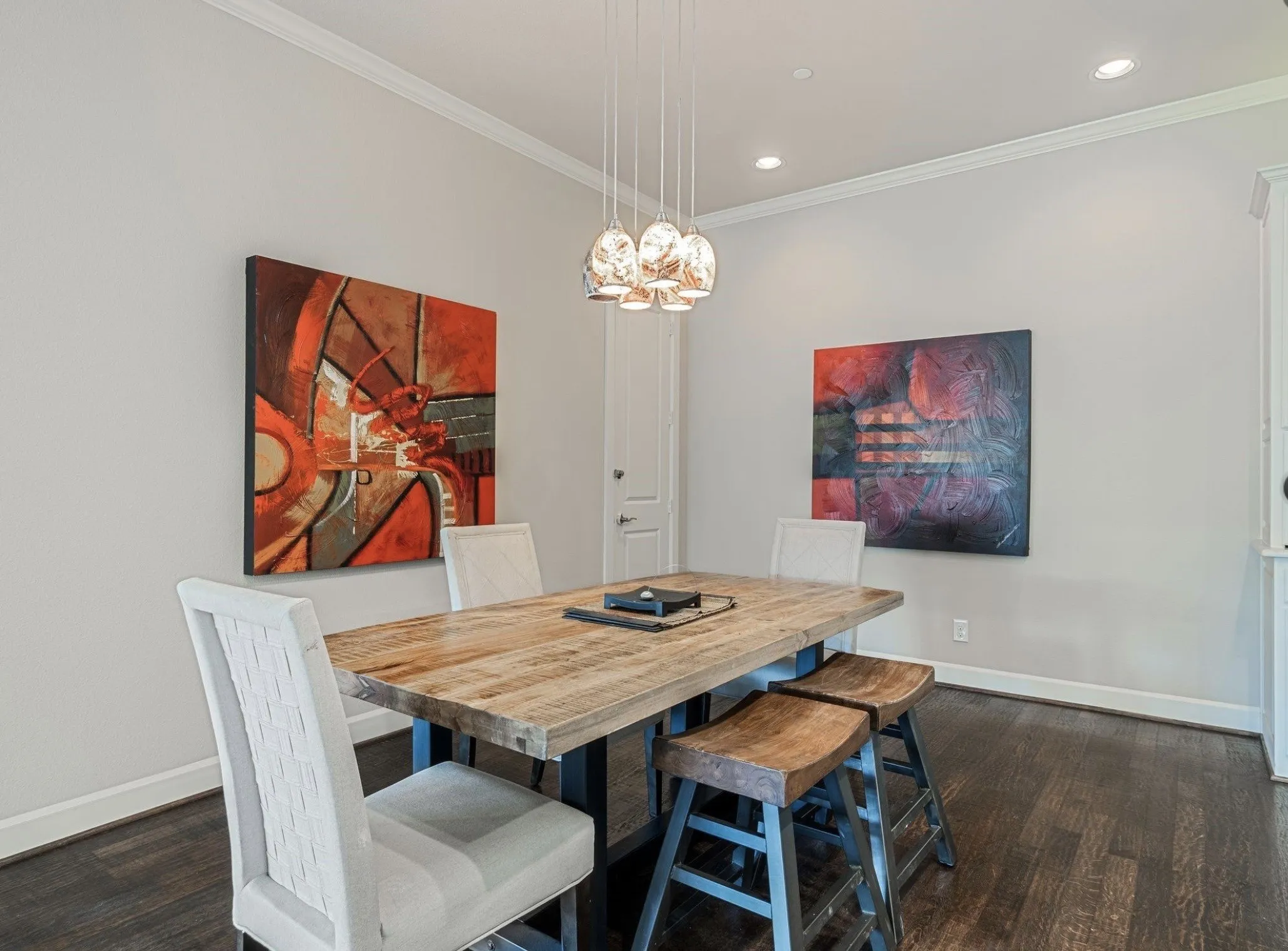 Dining area featuring dark wood-finish flooring, light gray walls, and white crown molding