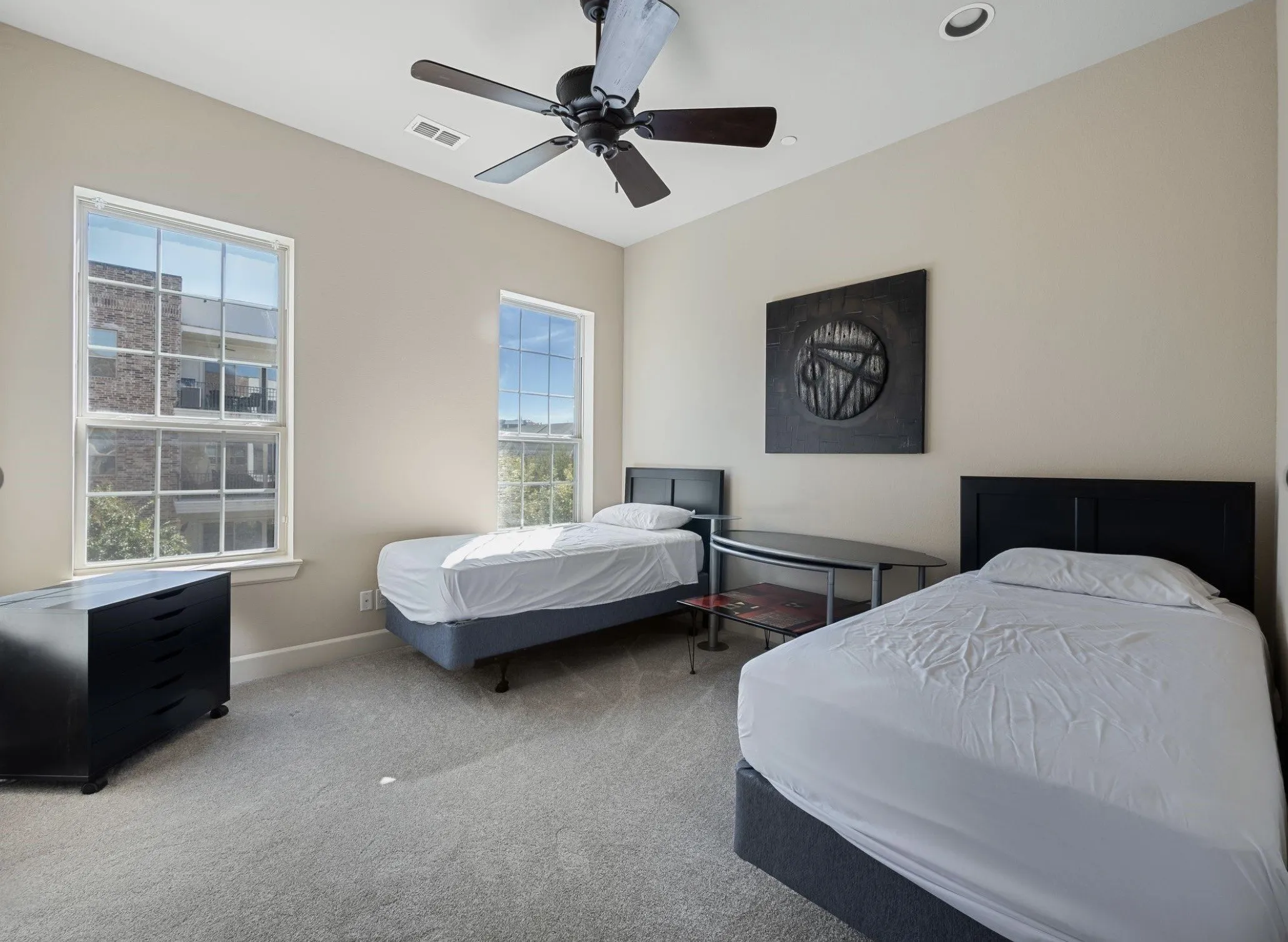 Light-filled room featuring two double-hung windows, a ceiling fan with integrated lighting, recessed lighting, and neutral-toned wall paint