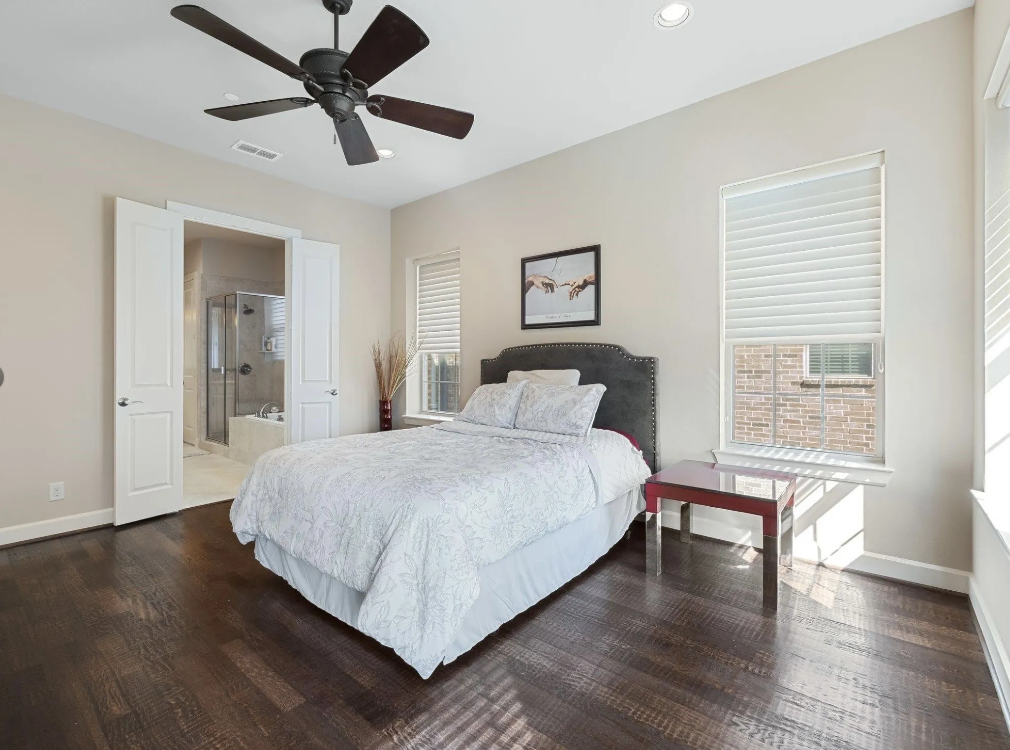 Bedroom featuring rich wood-finish flooring and a ceiling fan with dark blades